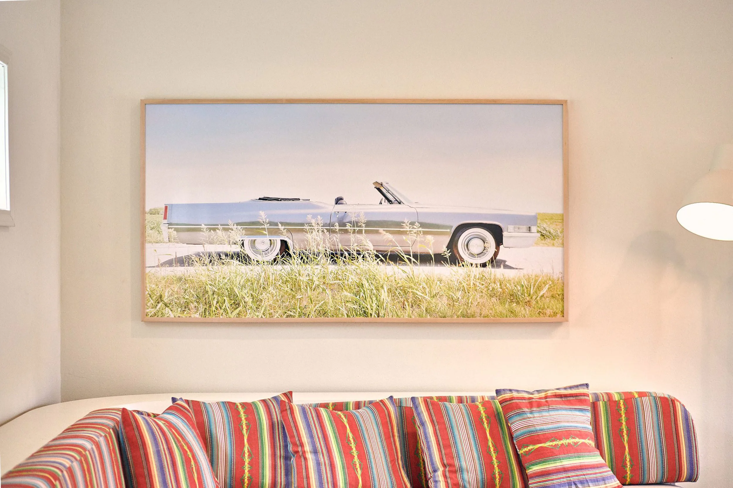 Austin Motel room with framed photo of blue car and colorful pillows