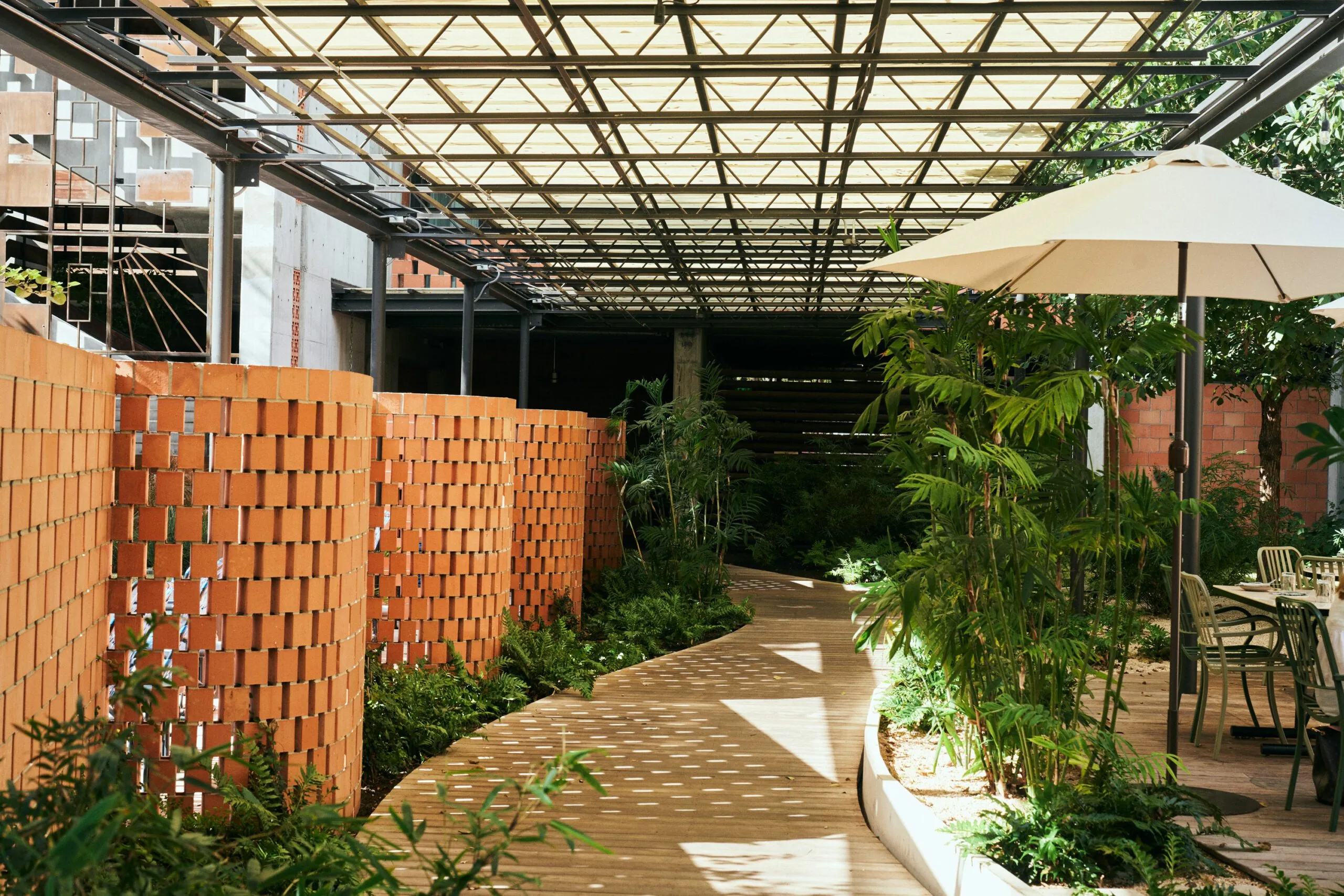 A covered wooden pathway with lush greenery
