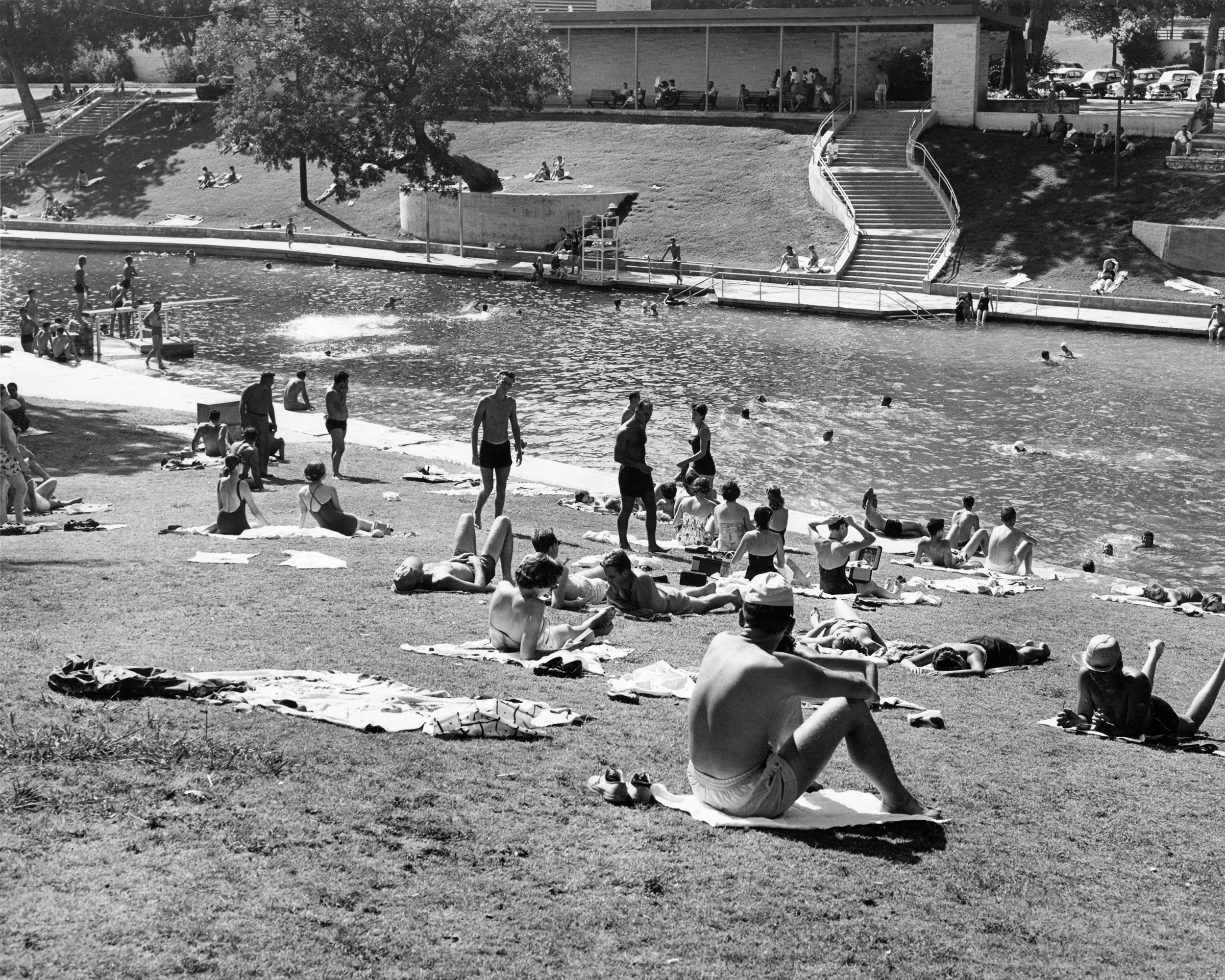 A crowd laying out and swimming at Barton Springs