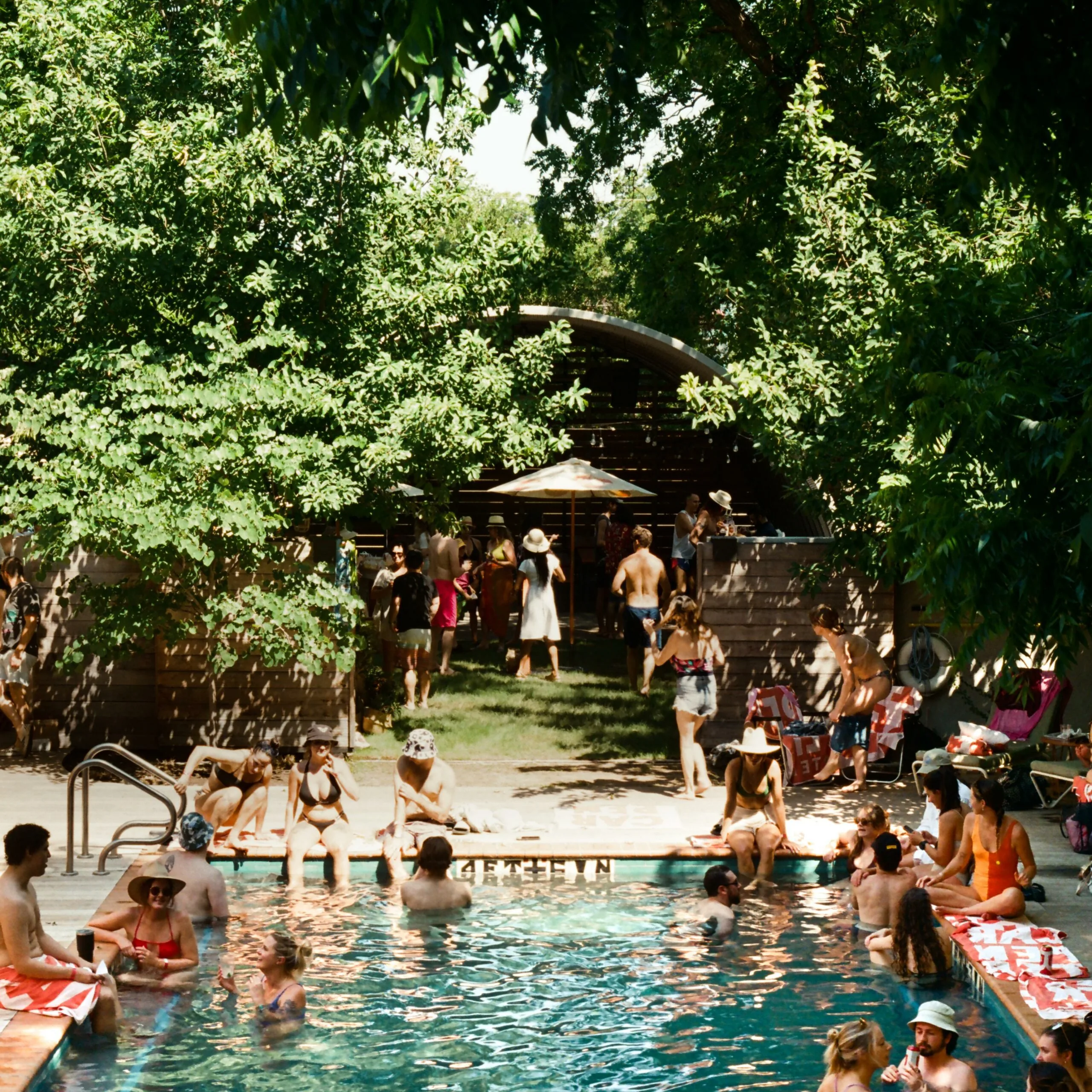 Guests enjoying the outdoor pool and greenery