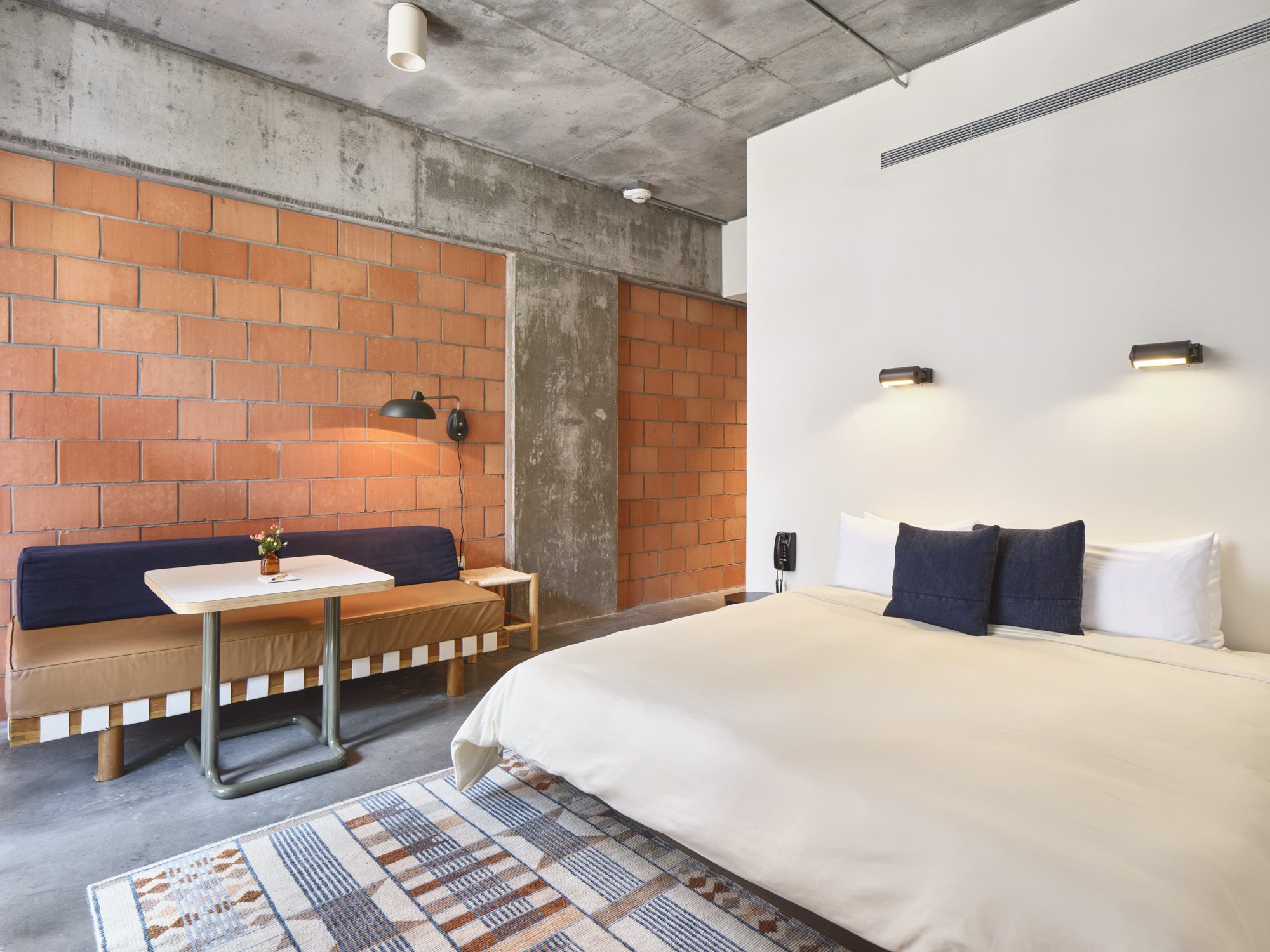 A king sized bed, a small couch, and table in the Standard King suite