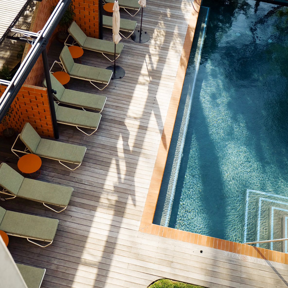 Green lounge chairs lined up near the Carpenter Hotel pool