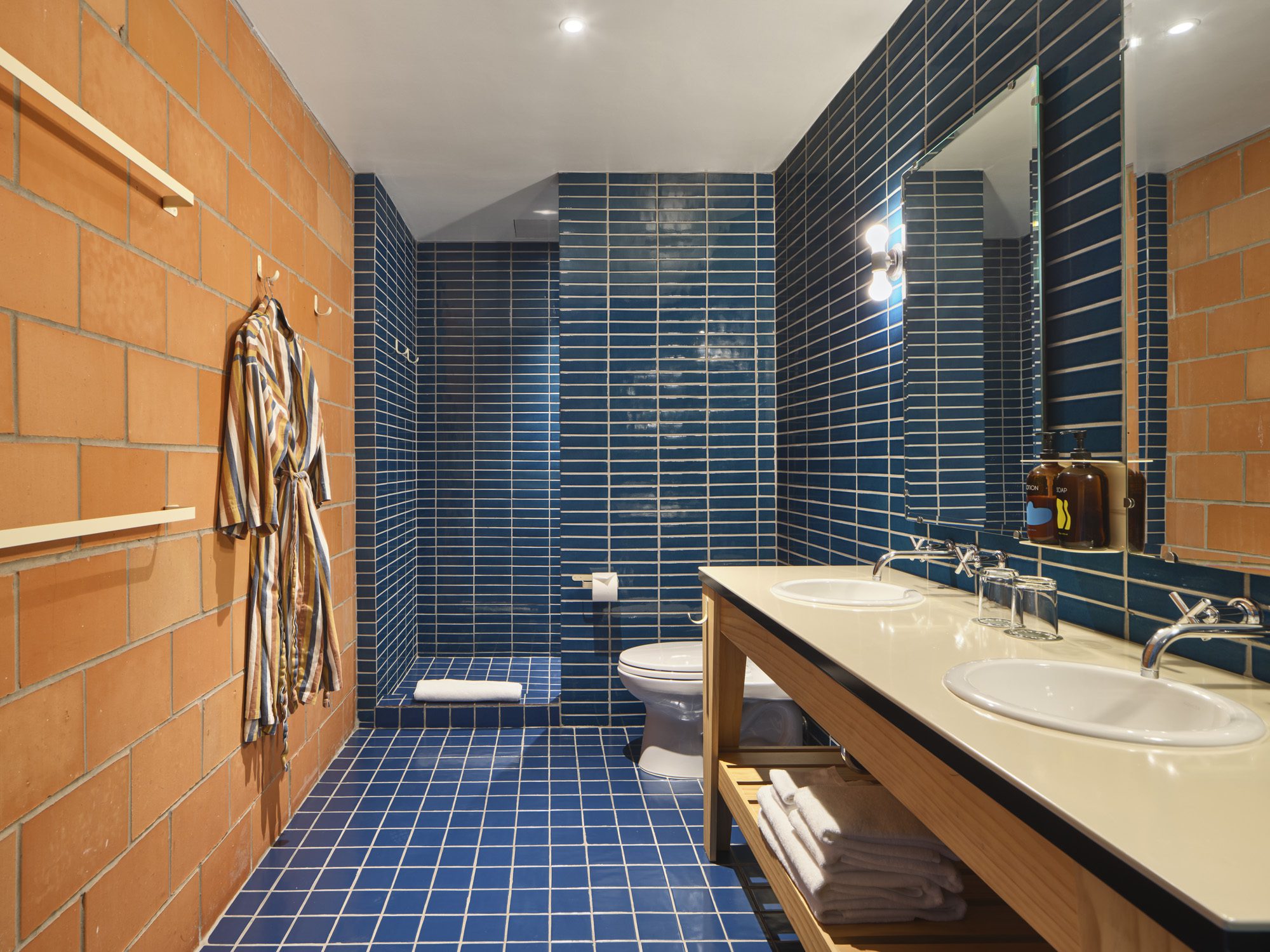 A blue tiled bathroom with double sinks in the Large King suite