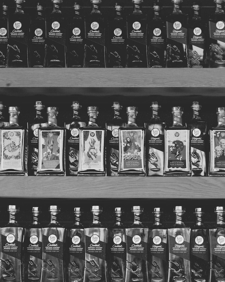 bottles of whiskey in rows lining a shelf