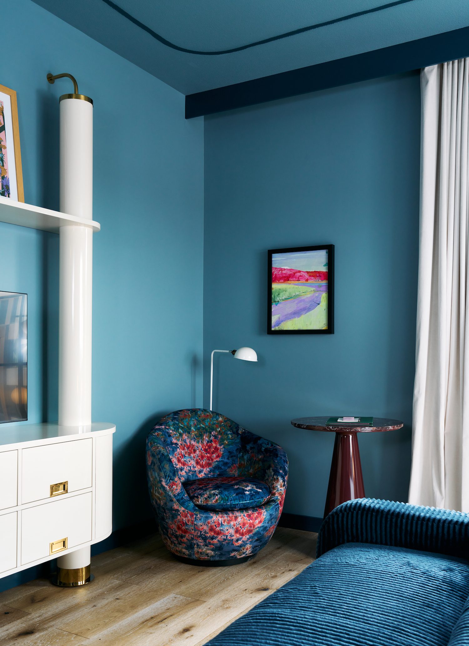 Corner view of a blue room with a decorative armchair