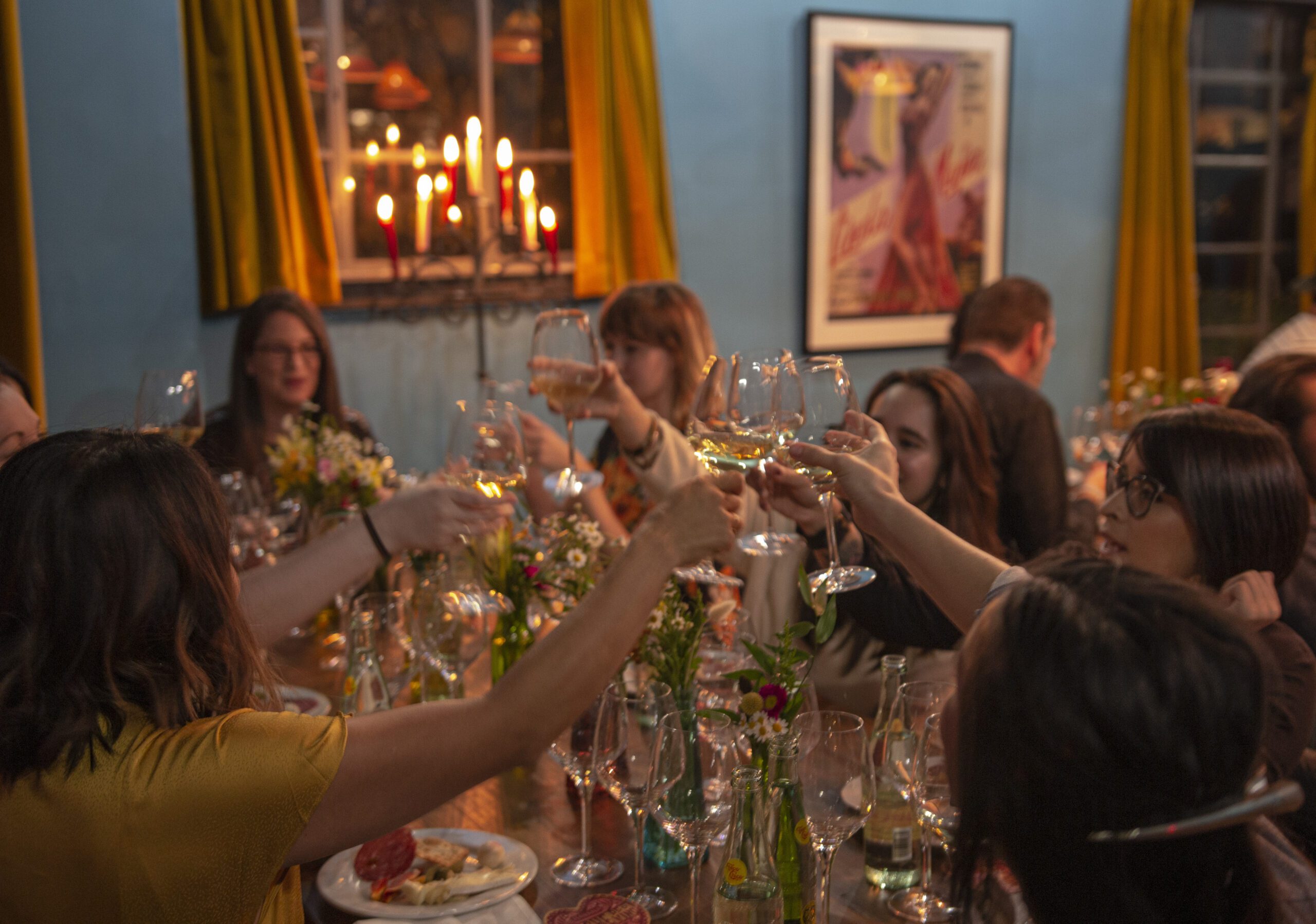 People raising their glasses over a dinner table