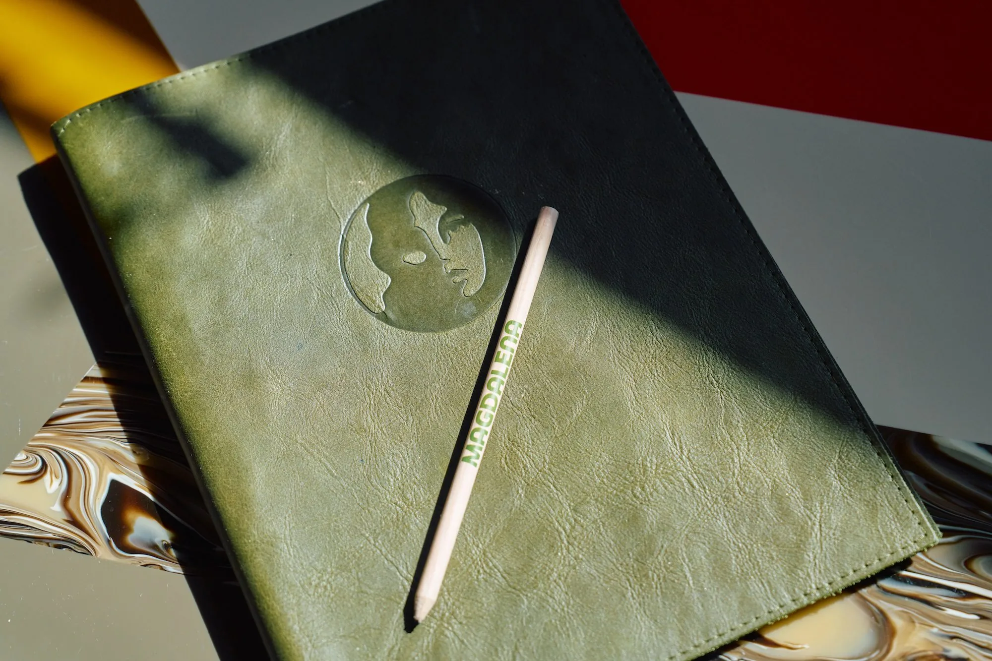green leather book with hotel logo