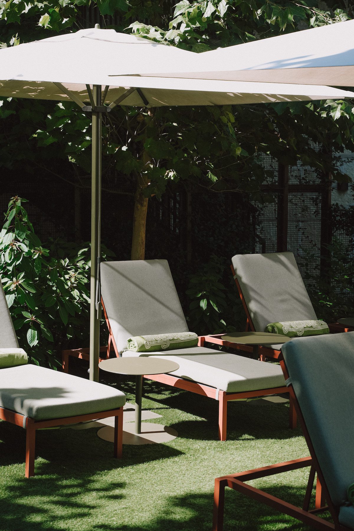 Lounge chairs, Hotel Magdalena pool towels and umbrellas in front of the pool