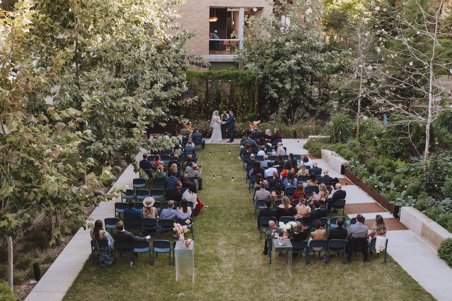 A couple getting married on the event lawn surrounded by beautiful lush greenery