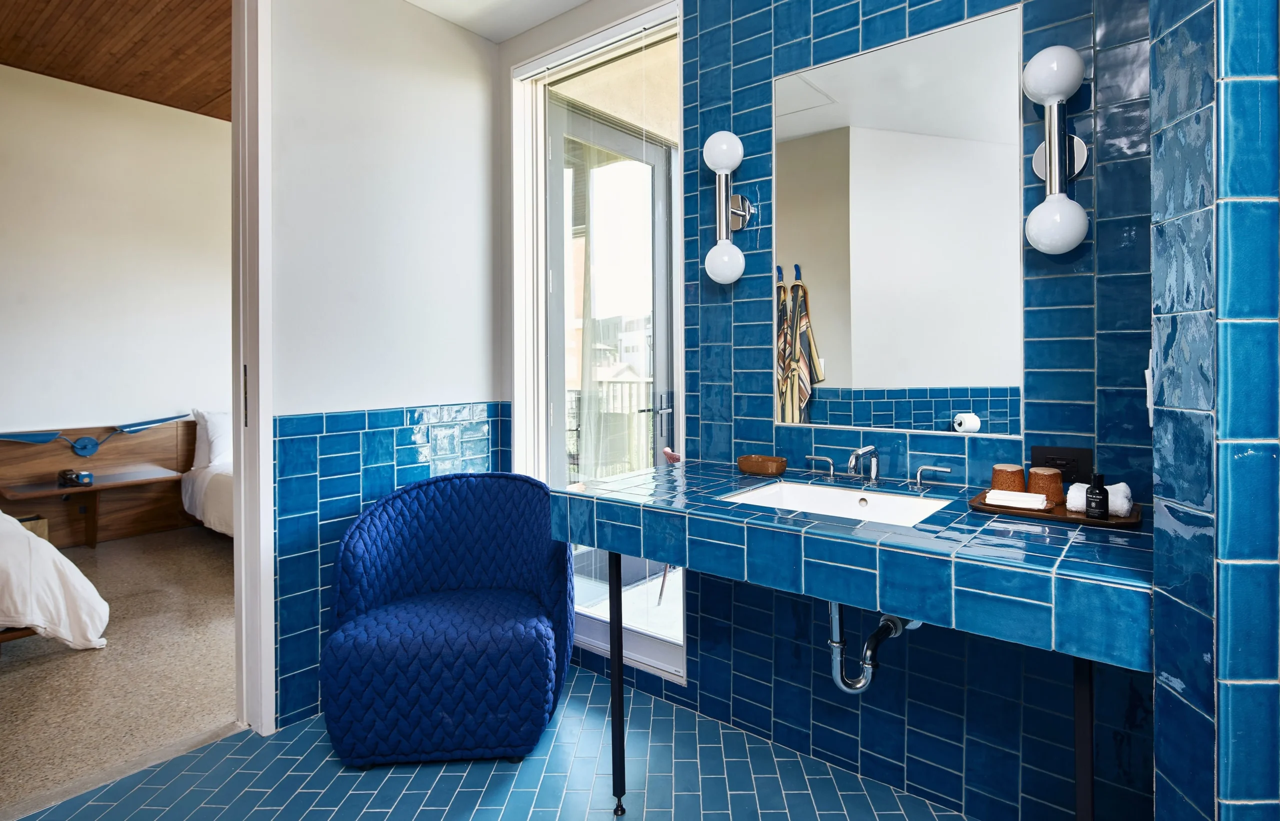 Blue bathroom with view of bed