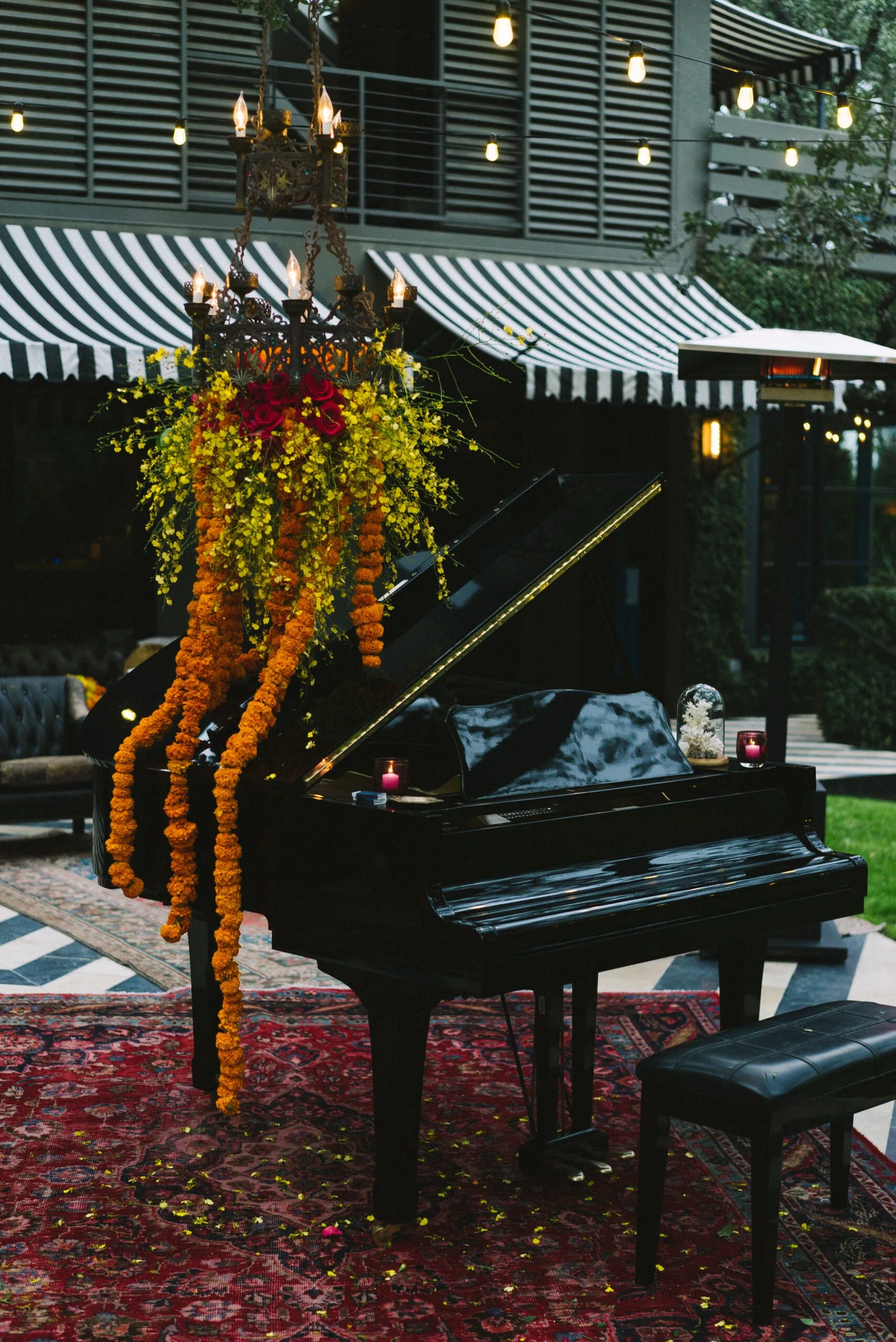 A piano in the courtyard with a chandelier and floral arrangement for Feast Day 2018