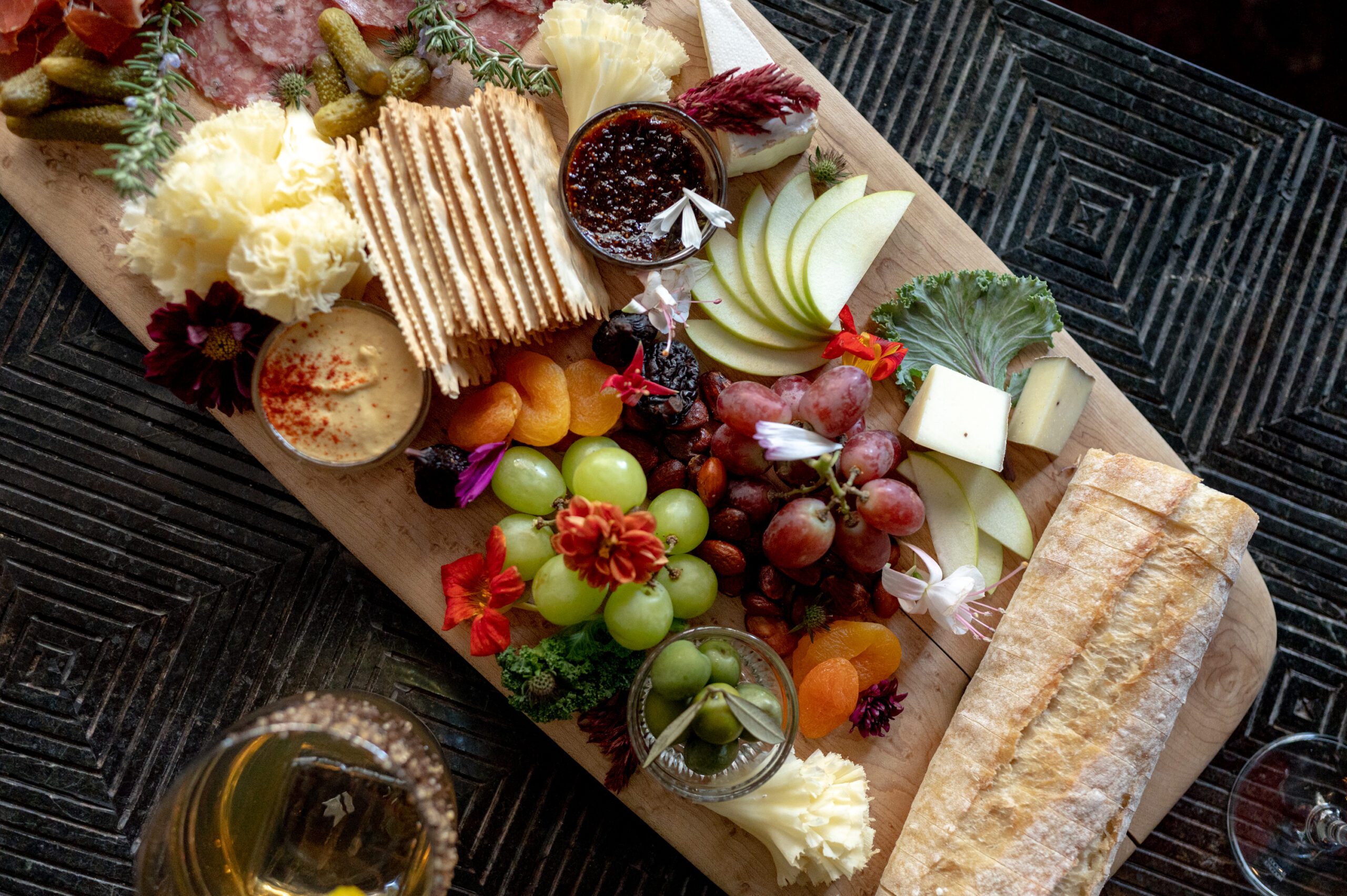 Cheeseboard with an array of fruits, crackers, jams, and cheeses