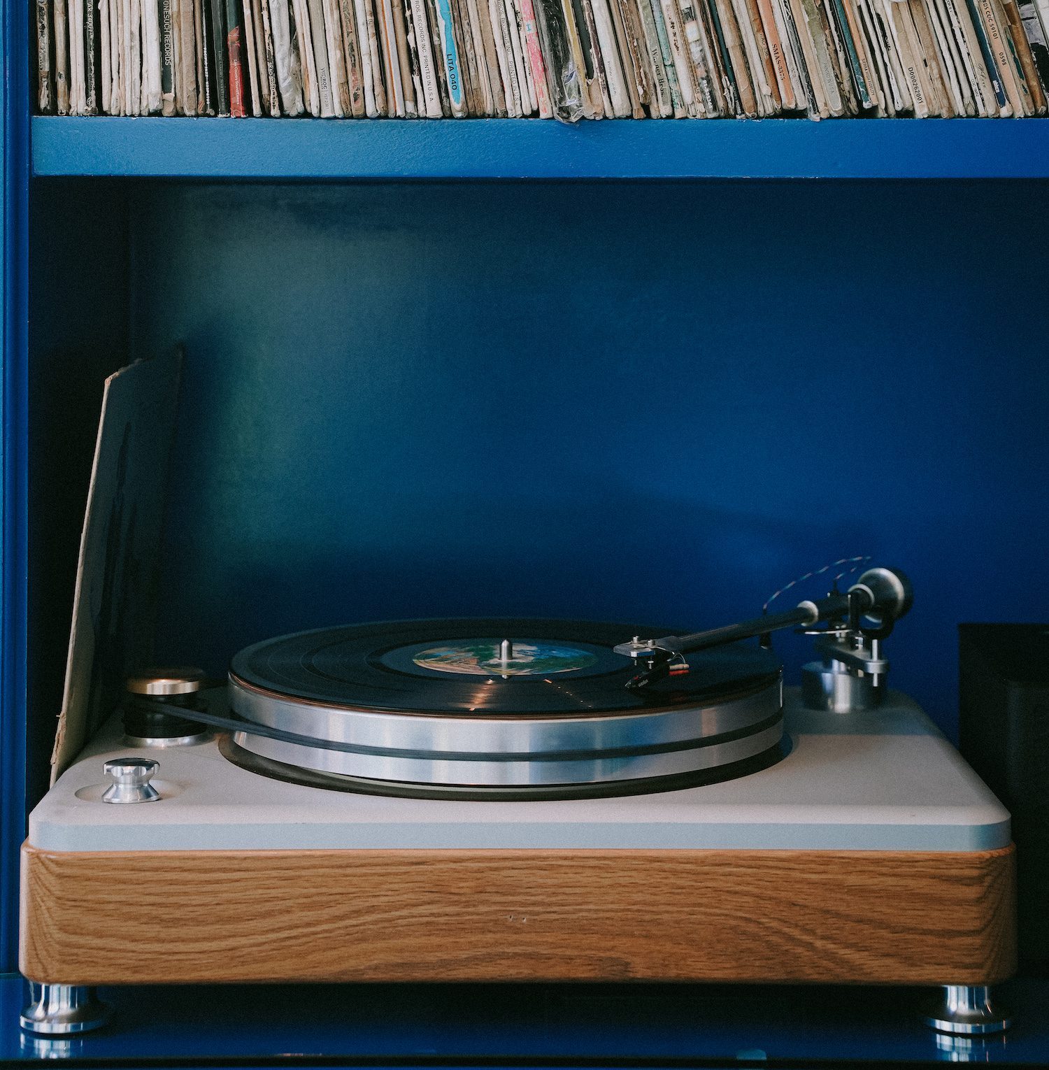 A record player with a shelf of records