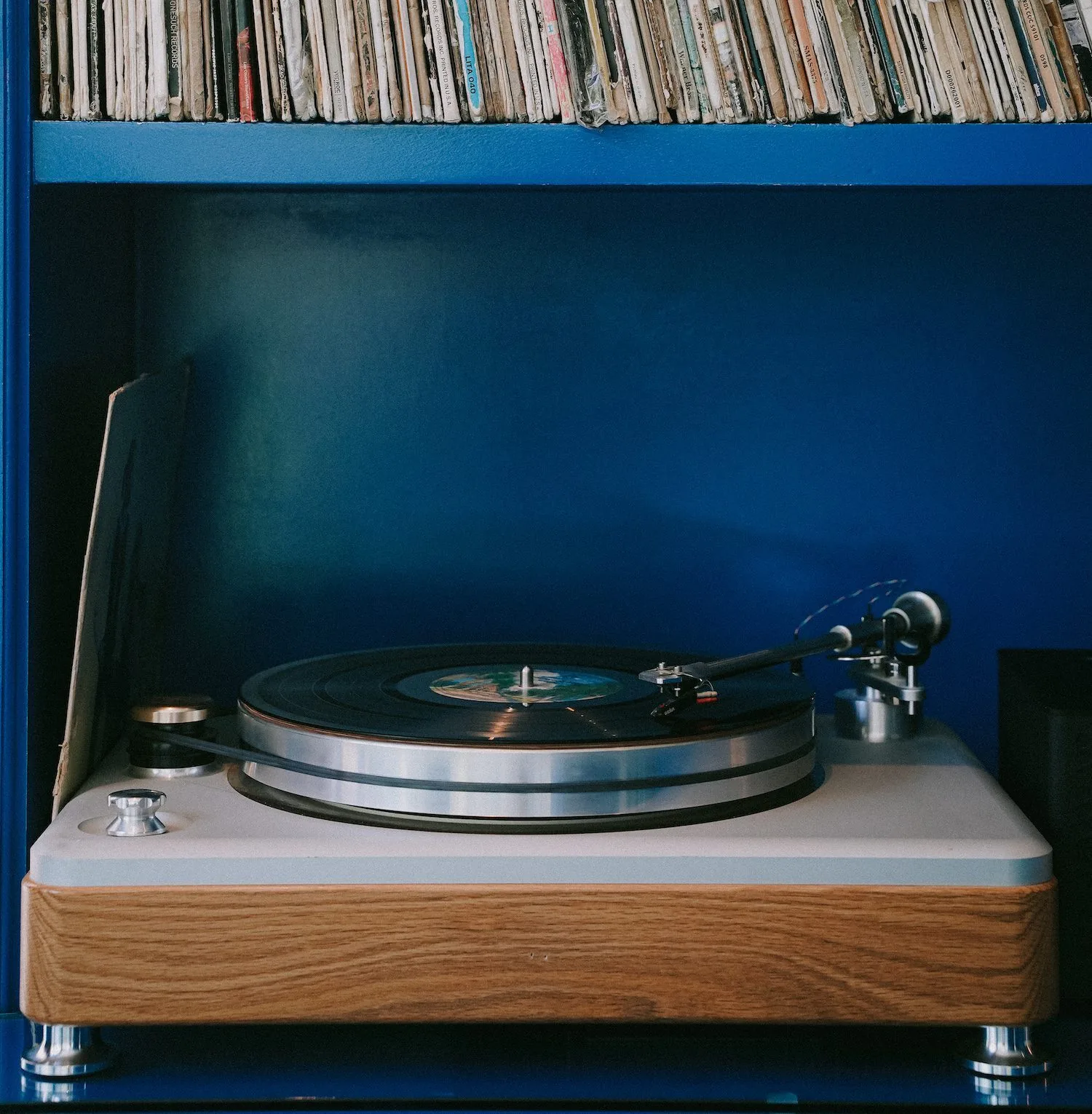 A record player with a shelf of records