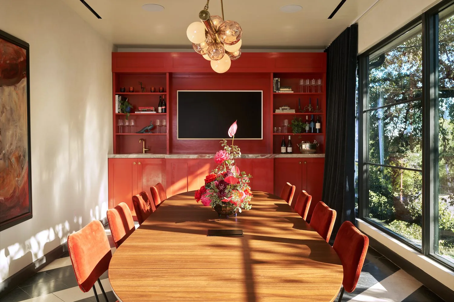 The Sun Room event space with long table and chairs with TV in background