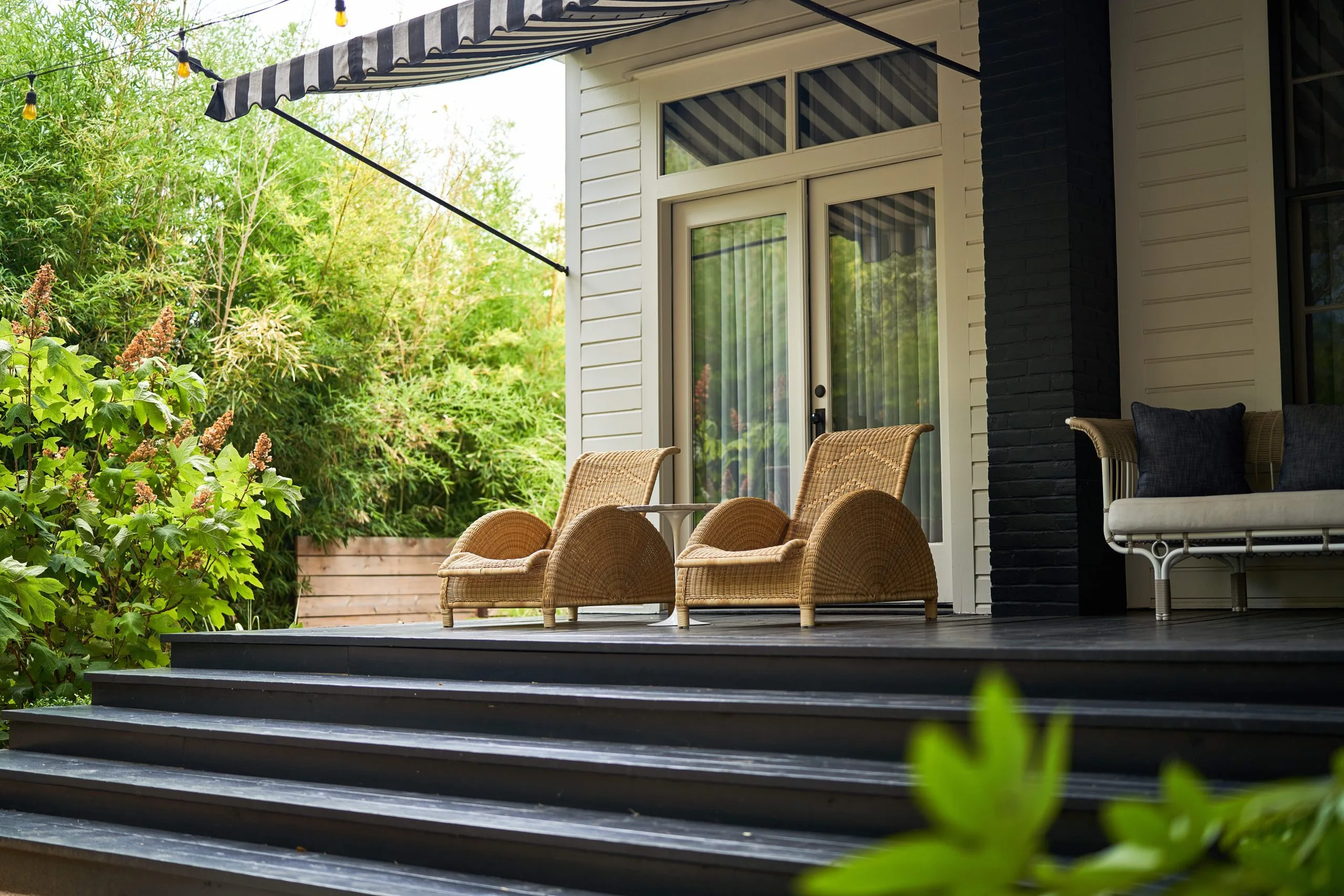 Two outdoor chairs under an awning