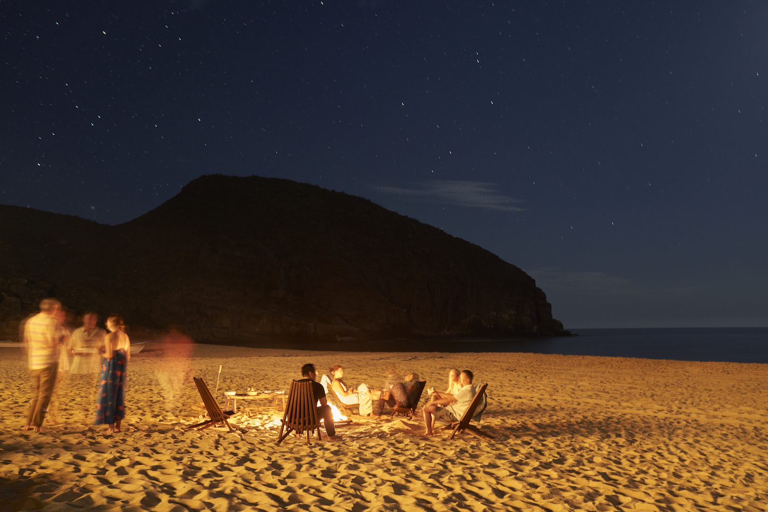 Nighttime gathering around a fire on the beach