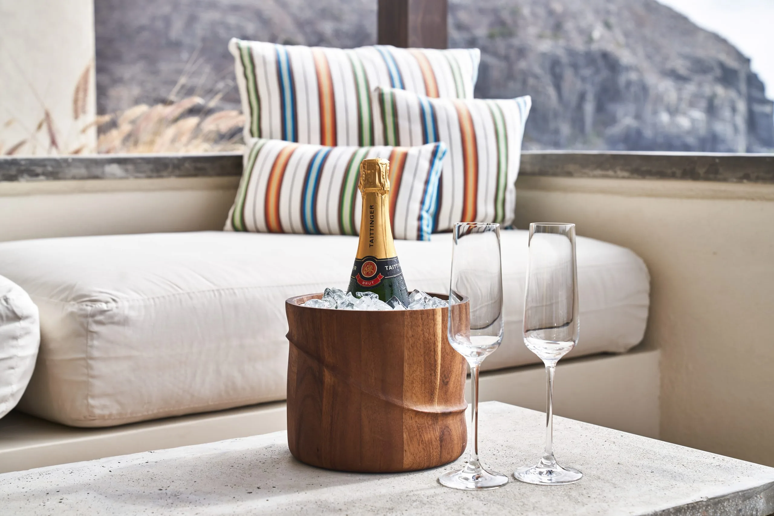 Ice box containing a bottle of champagne beside two glasses