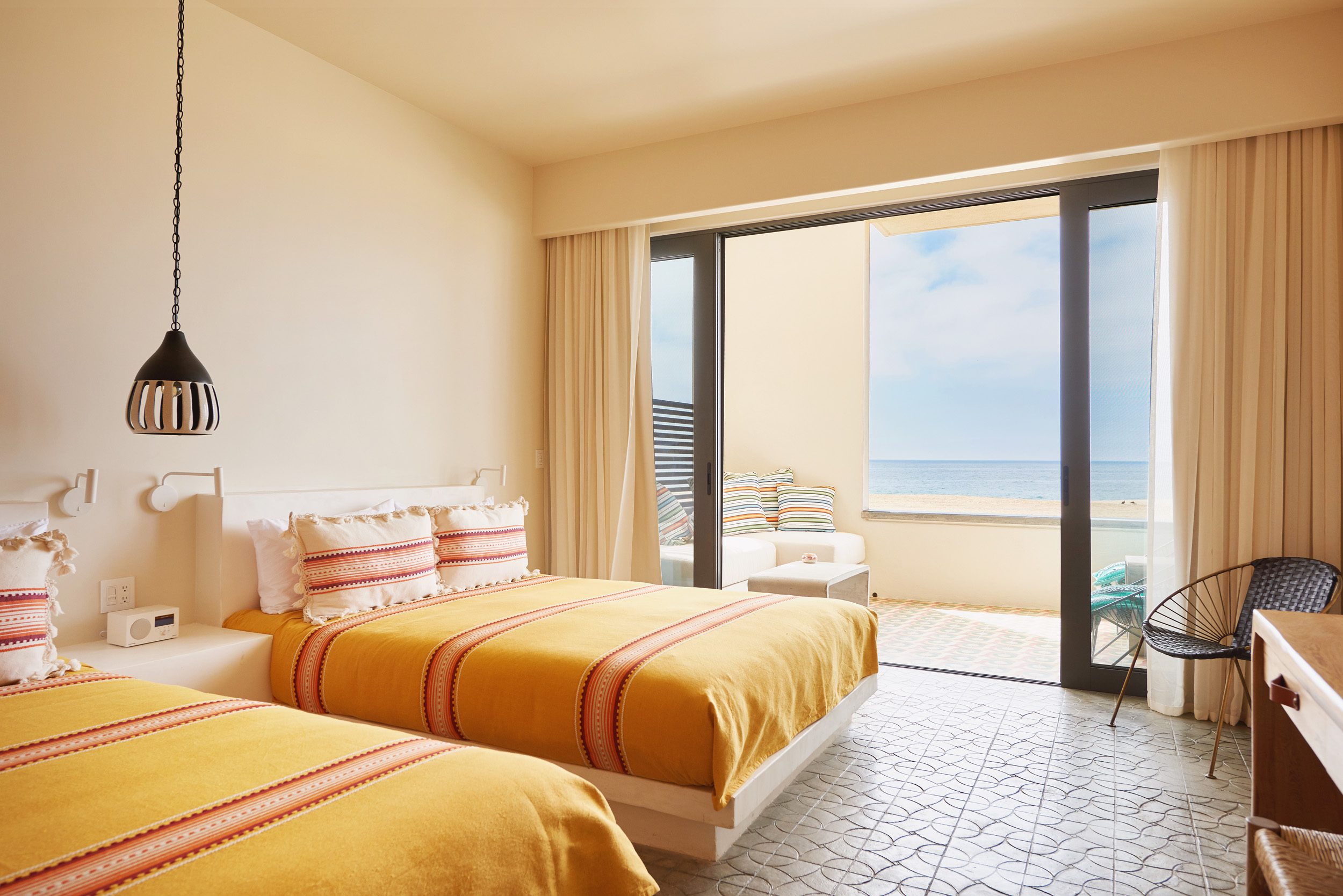 Front view of two double beds next to a window with ocean views