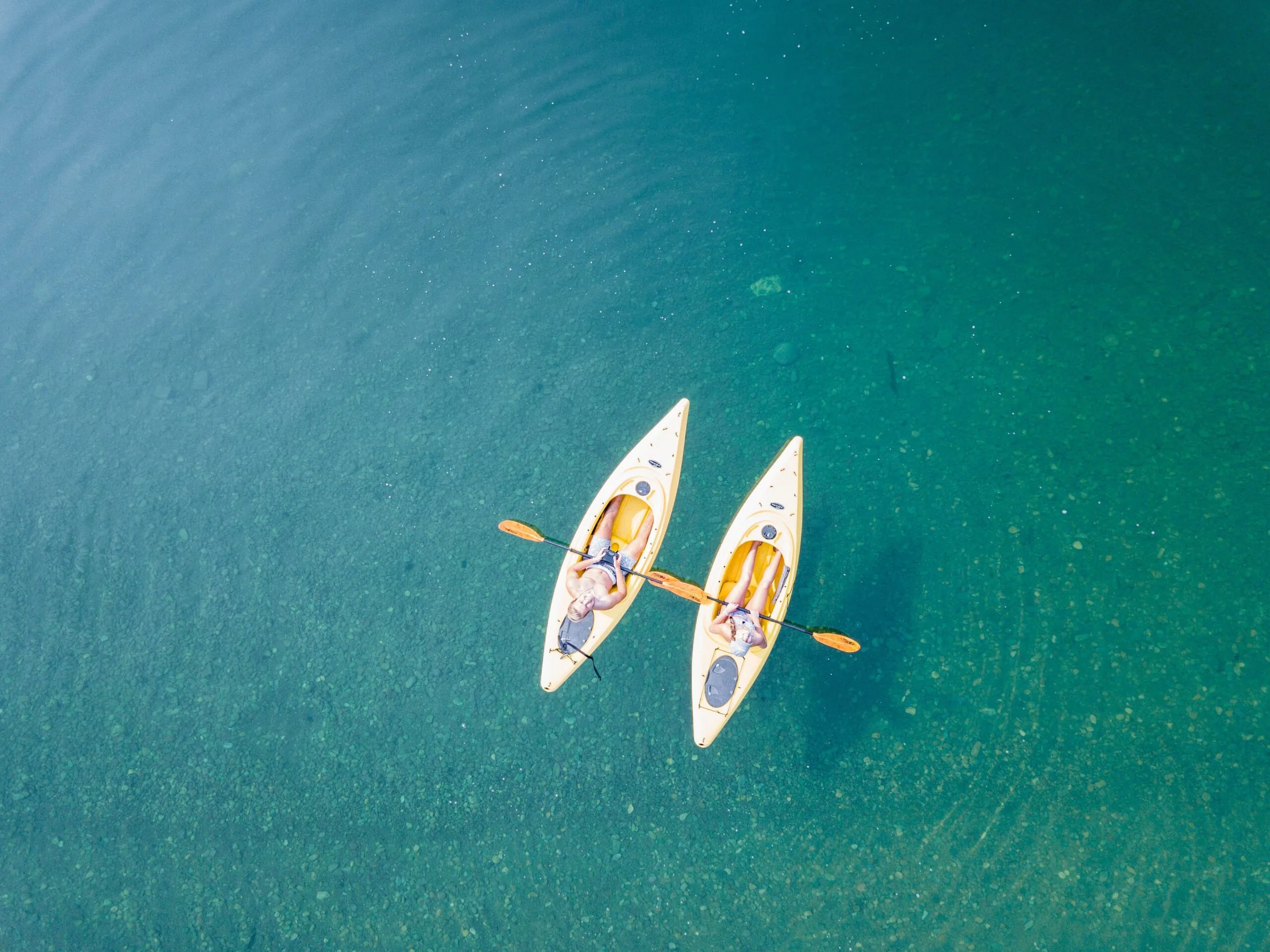 couple on individual kayaks floating in ocean