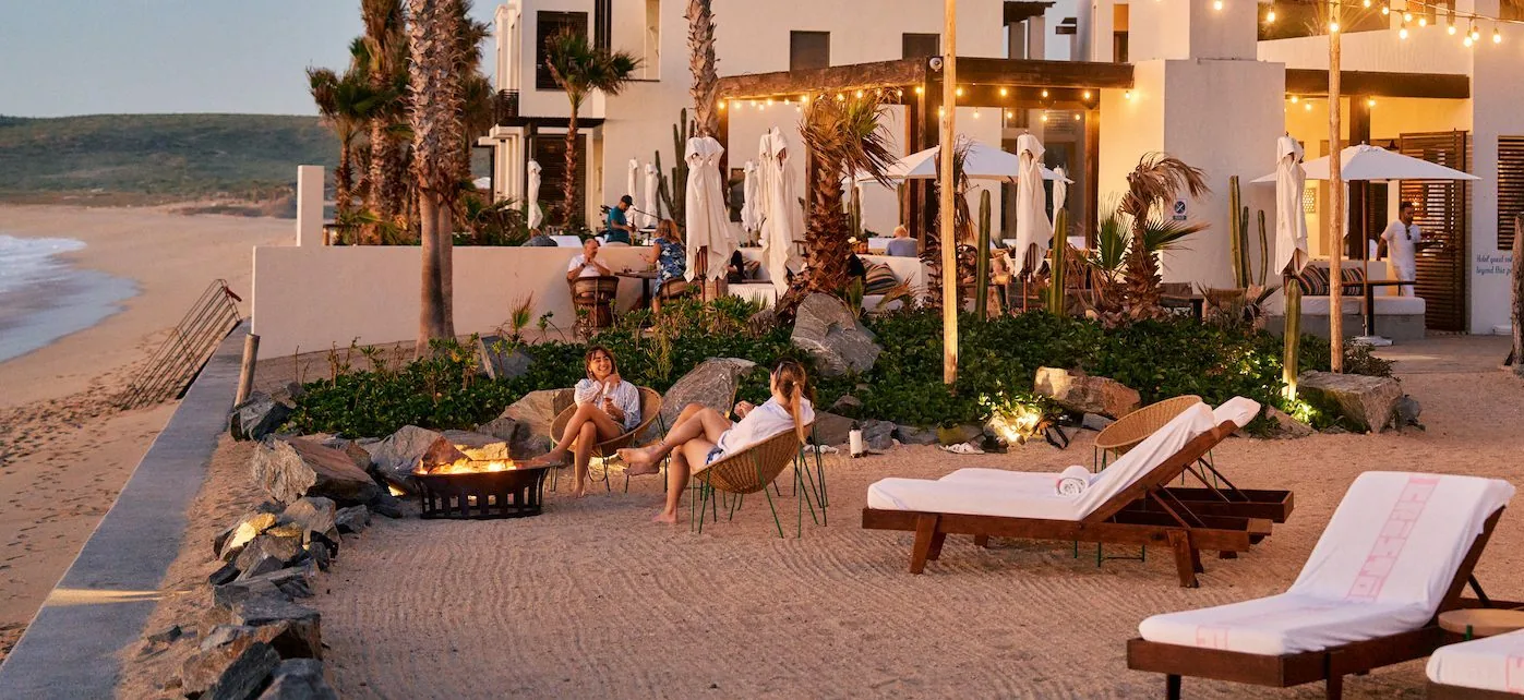loungers on a beach at sunset, people enjoying the view