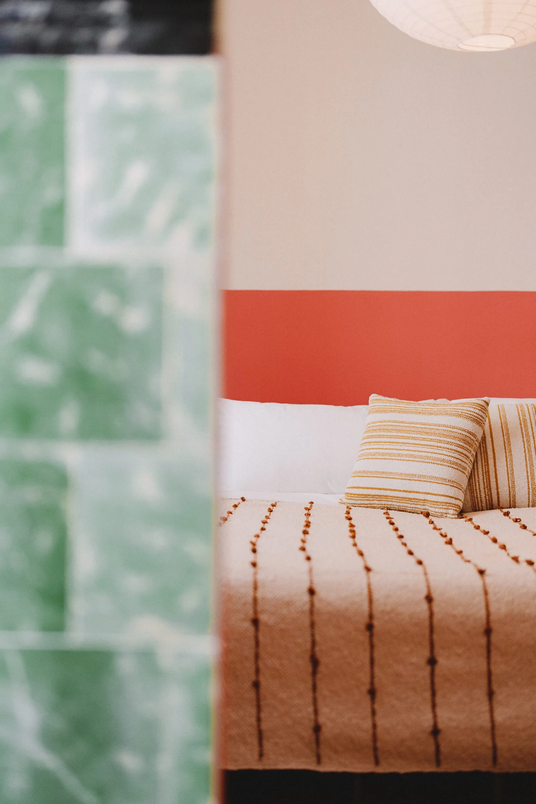 A king-sized bed framed by a green tiled entryway