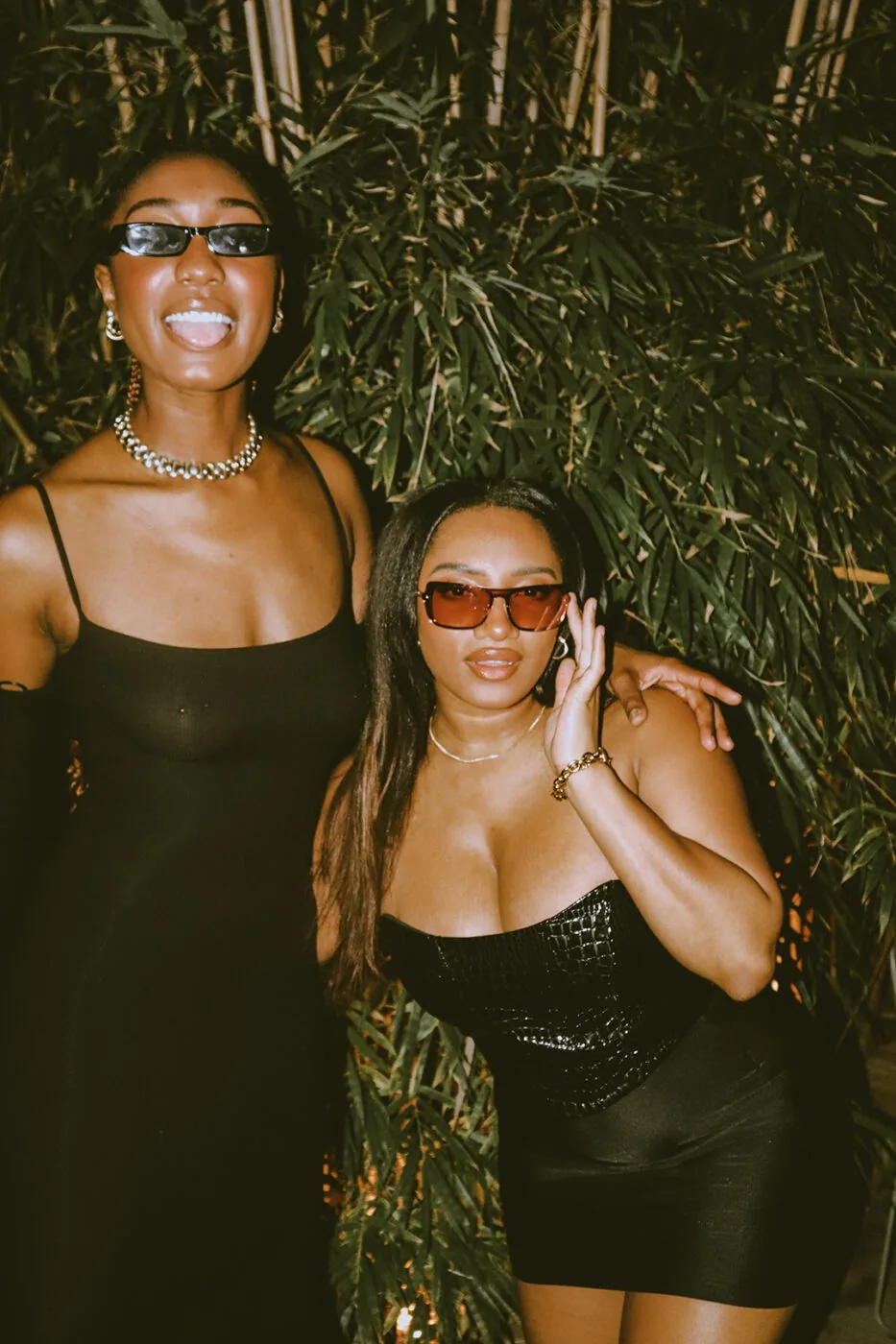 Two women wearing black posing for the camera
