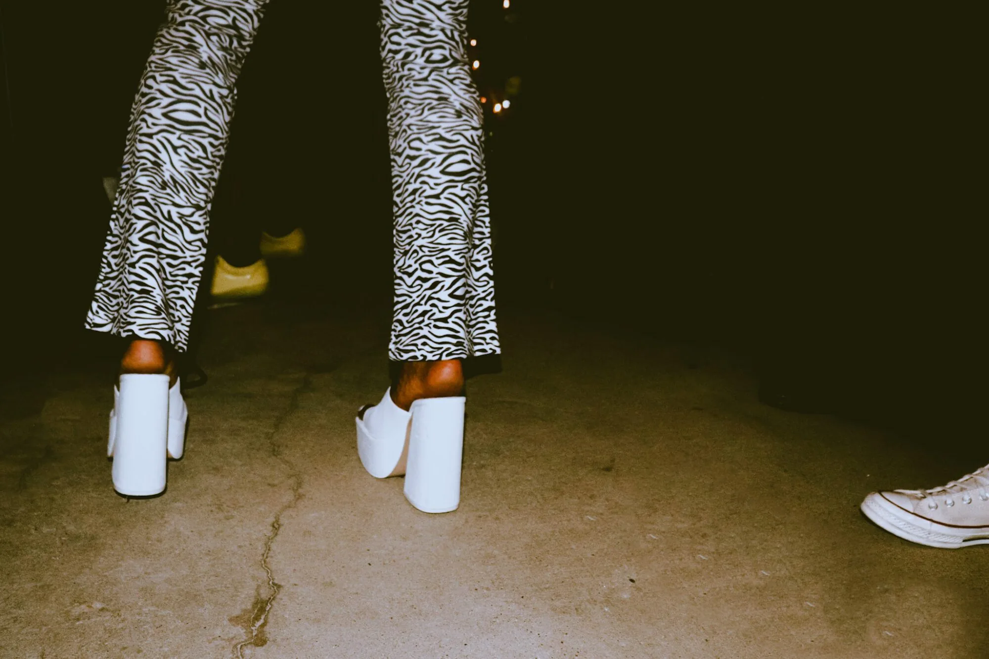 View of woman in platform white shoes and zebra stripe trousers