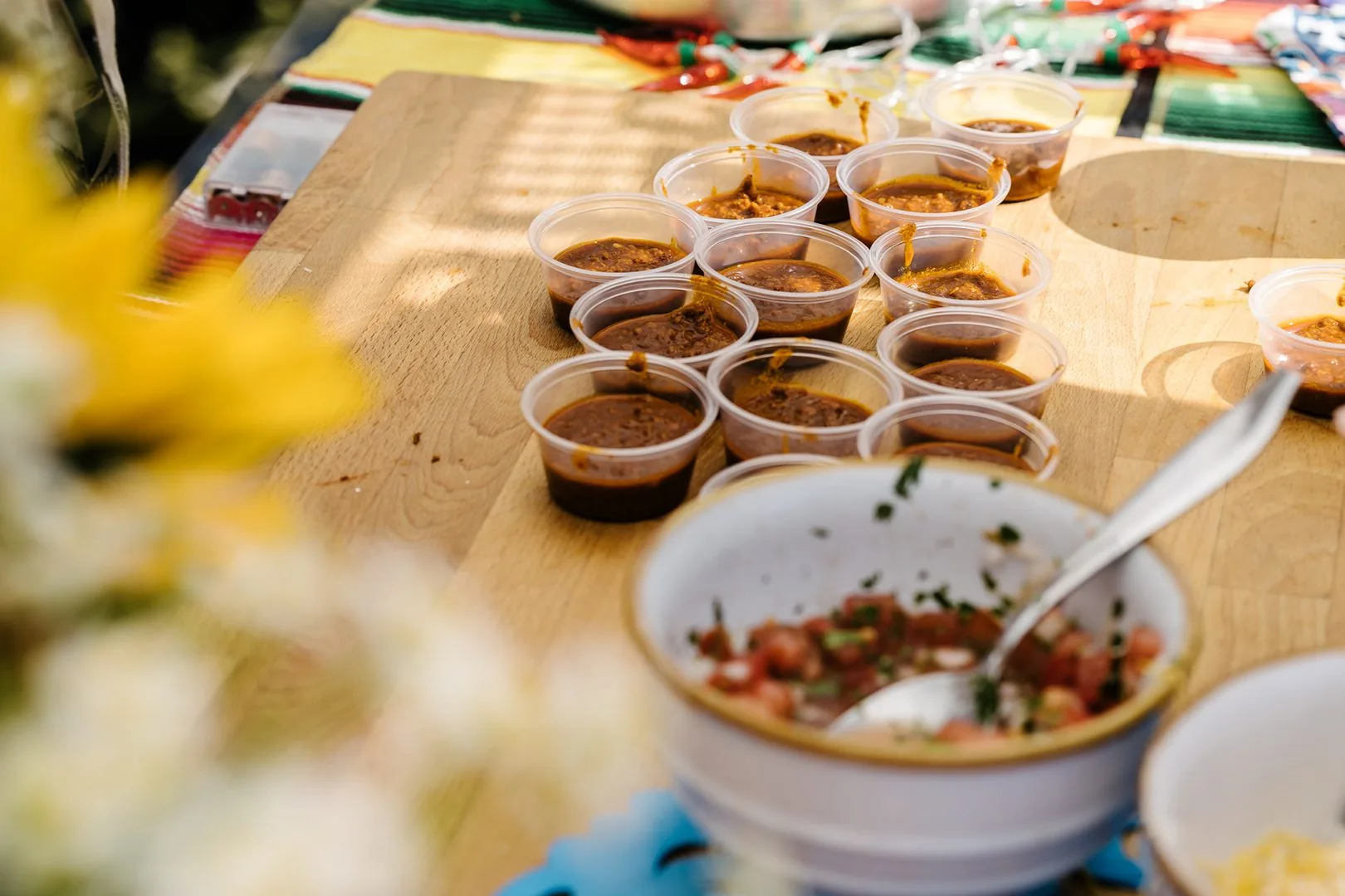 A table with chilli samples and a bowl of salsa