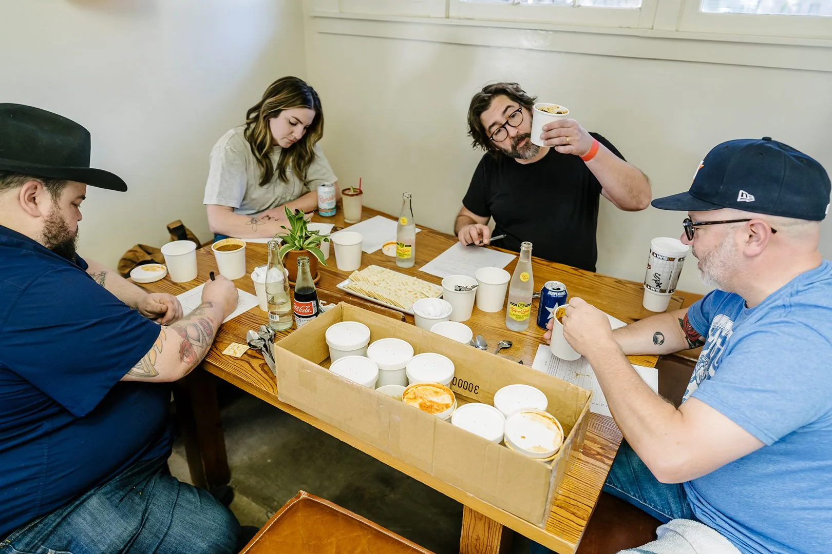 People sitting around a table sampling chilli