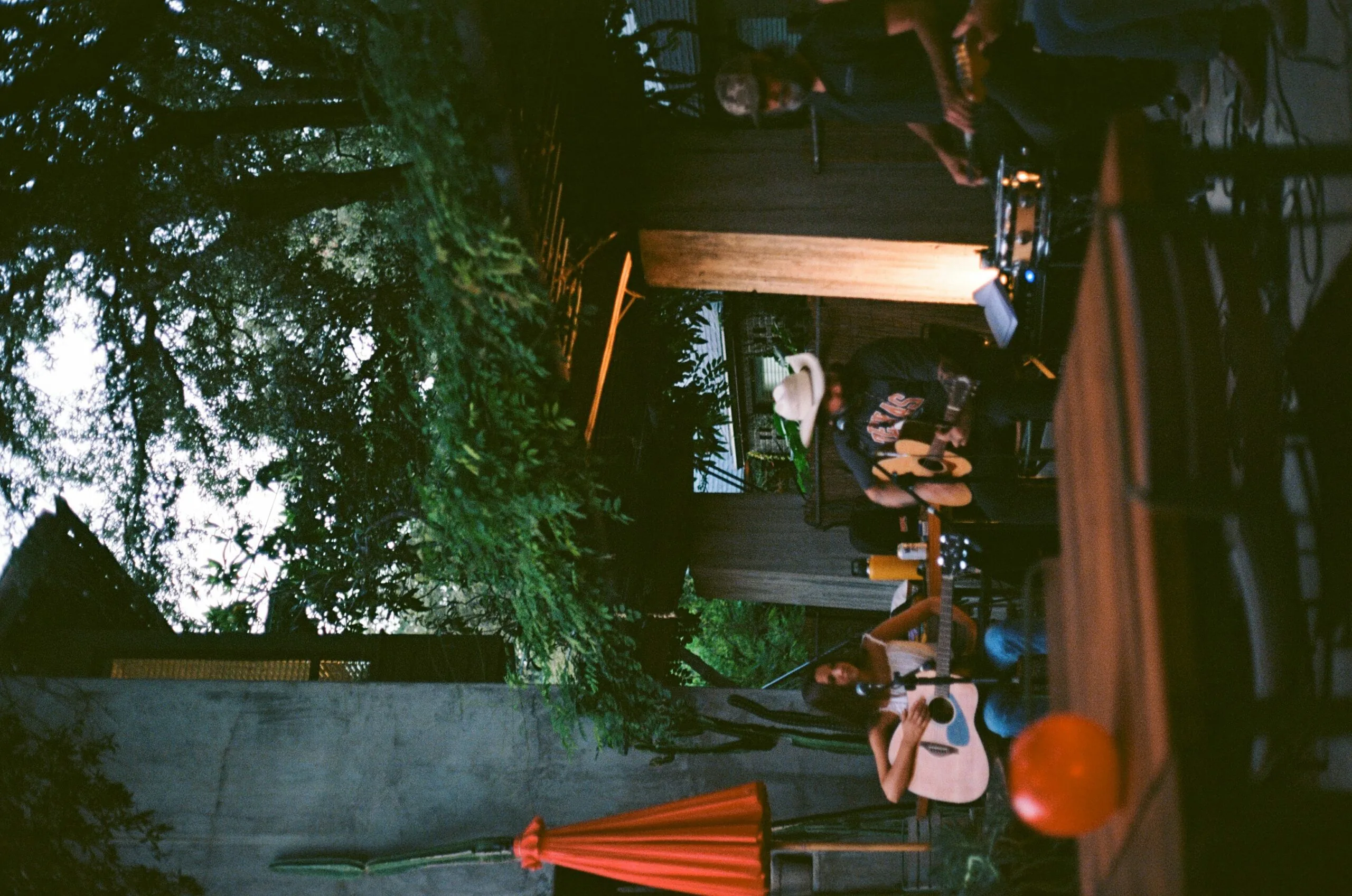 A band playing music in an outdoor dining space at evening time