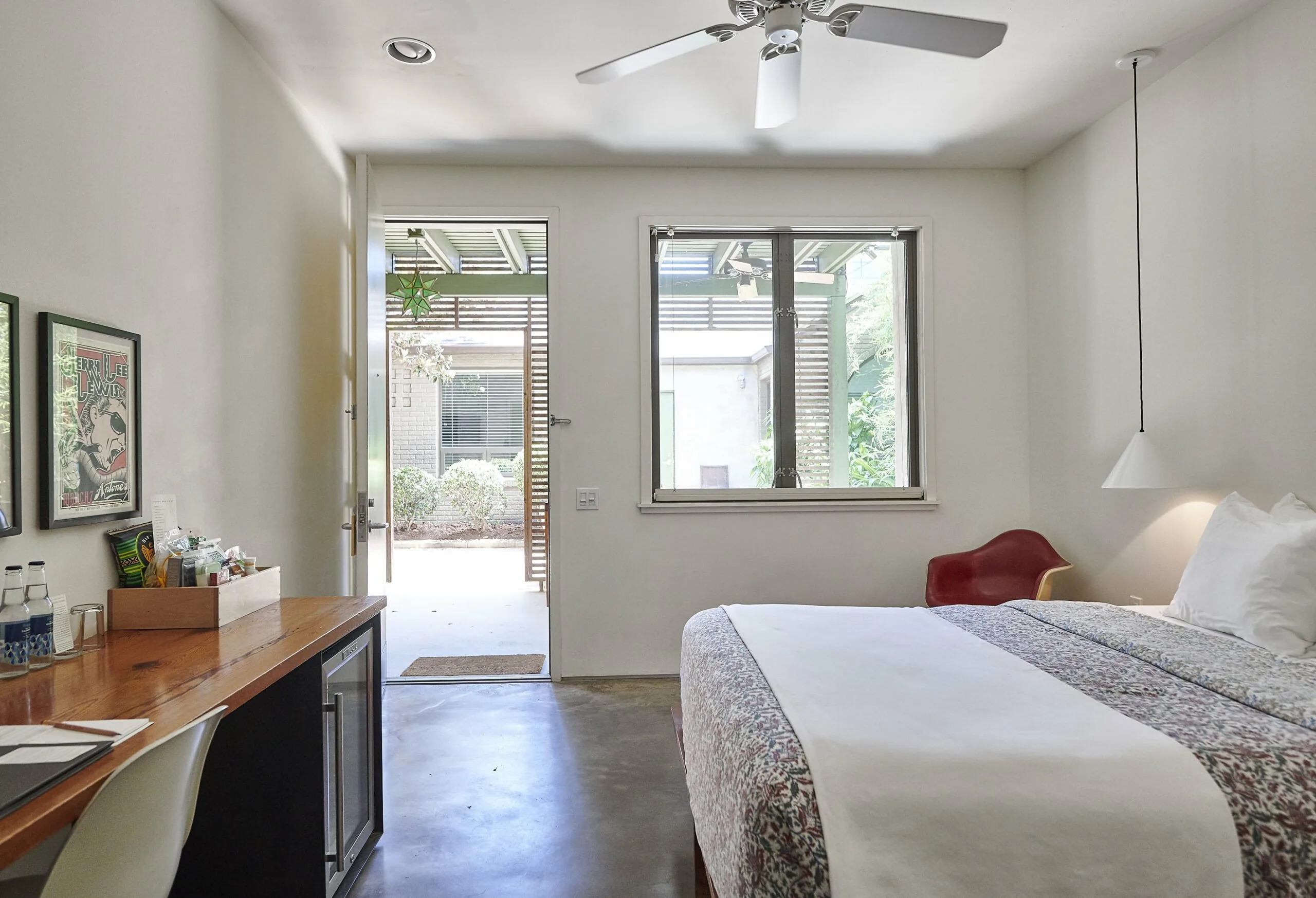 View of Grand Standard Room 42, looking from the bathroom out to the door way; door is open, bed is made