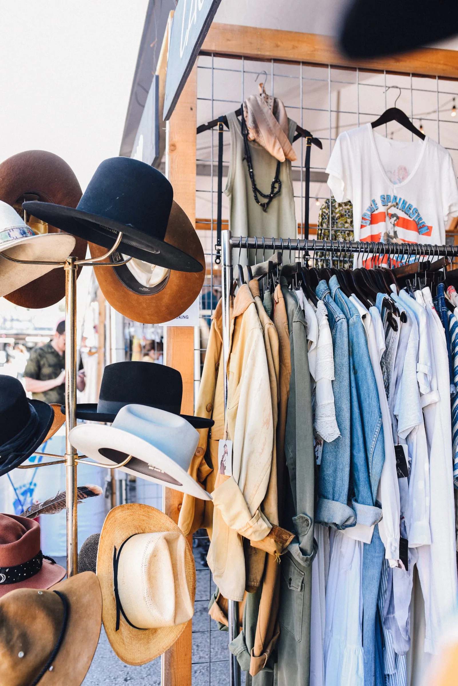 A market stand with various clothing and hats for sale