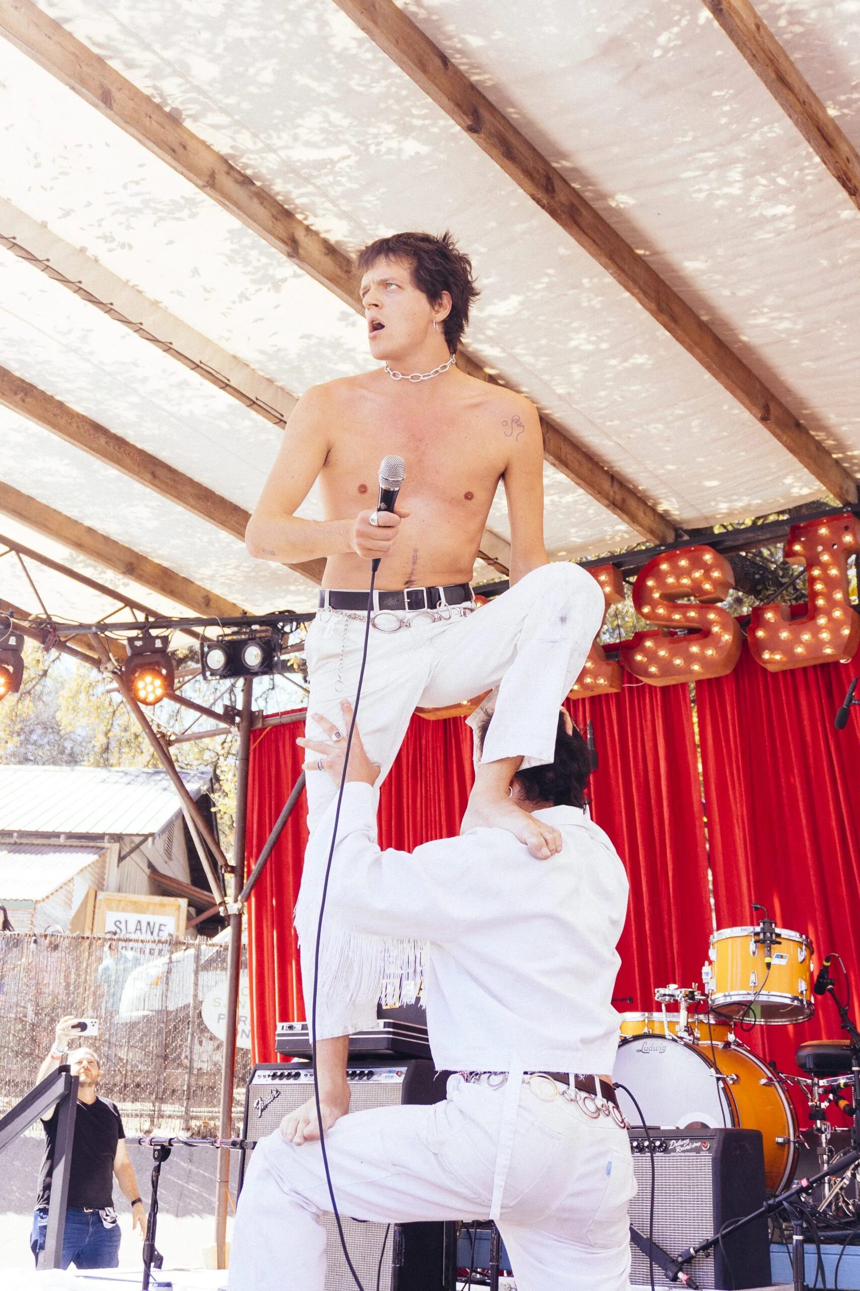 Stage performer standing on shoulder of another peformer