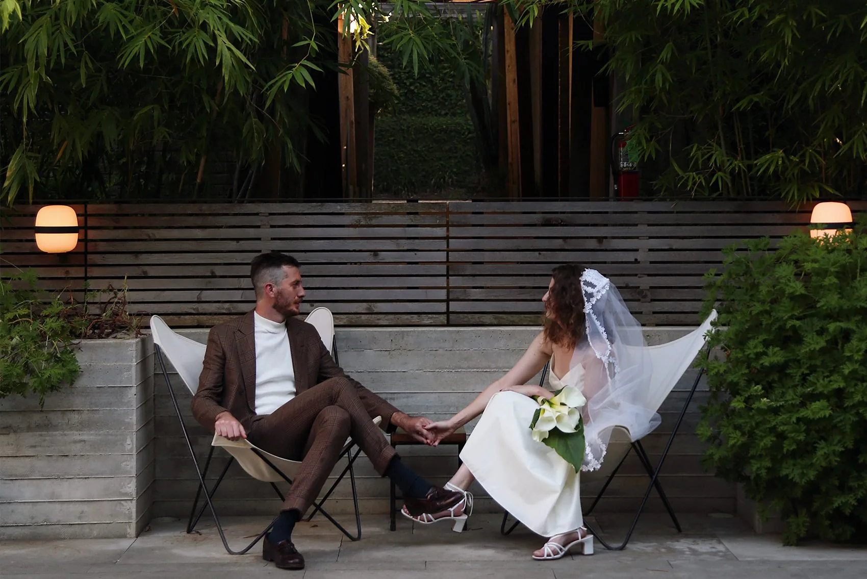 wedding couple sitting down holding hands