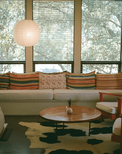 Hotel San Jose room with a view towards the window, white sofa with colorful pillows, cowhide rug and coffee table