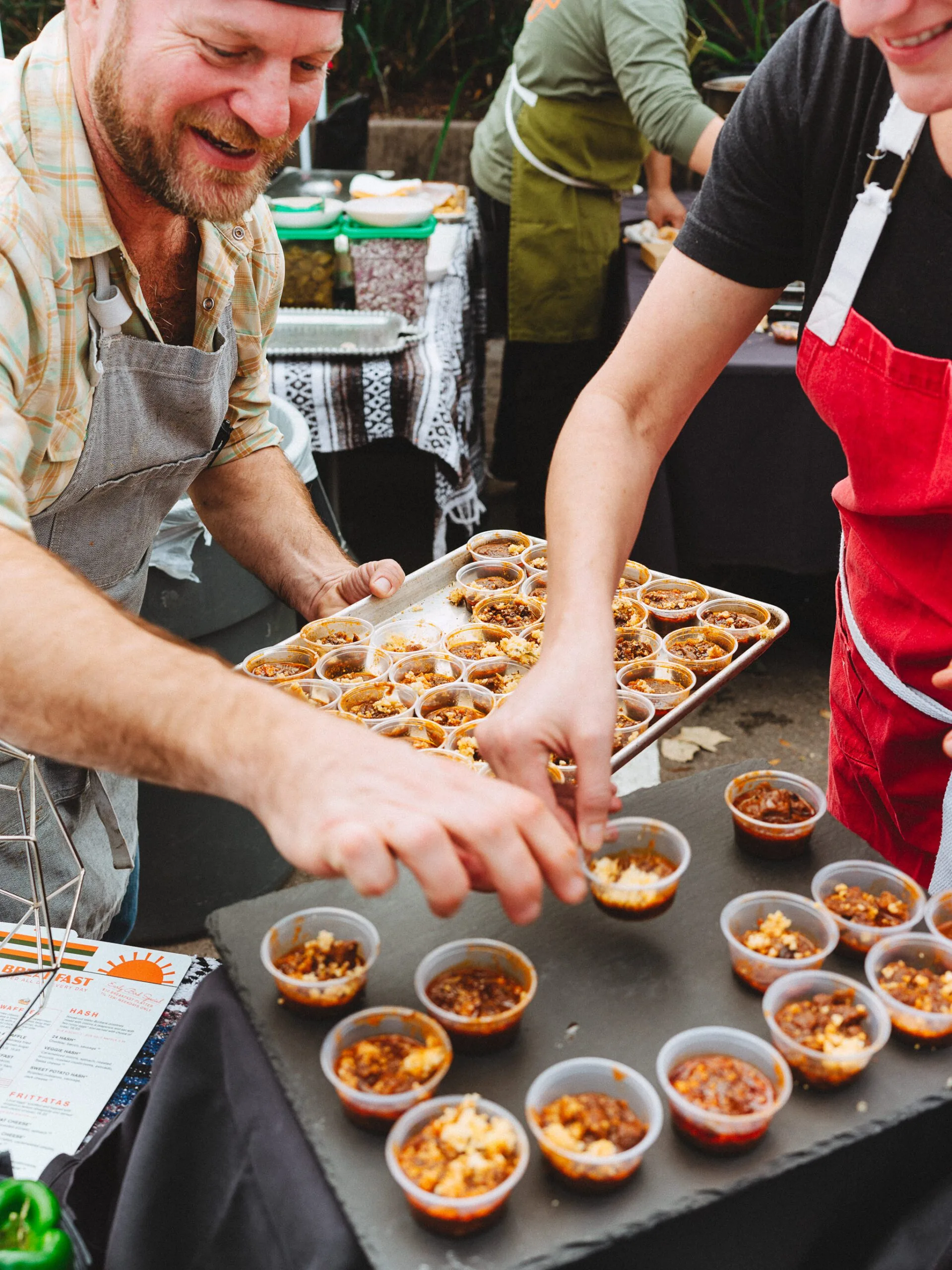 people putting sample food in small containers