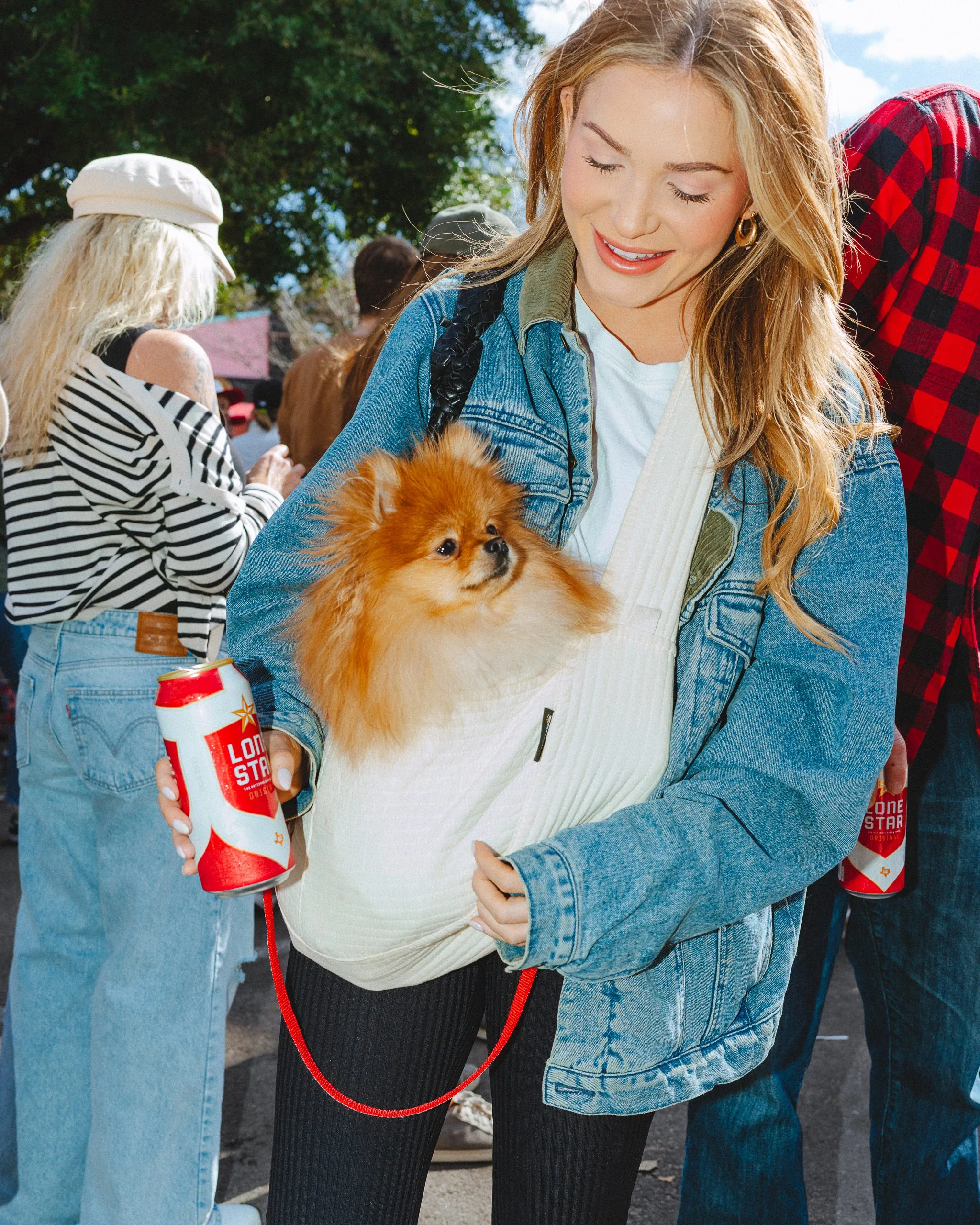 woman carrying pomeranian dog in a bag