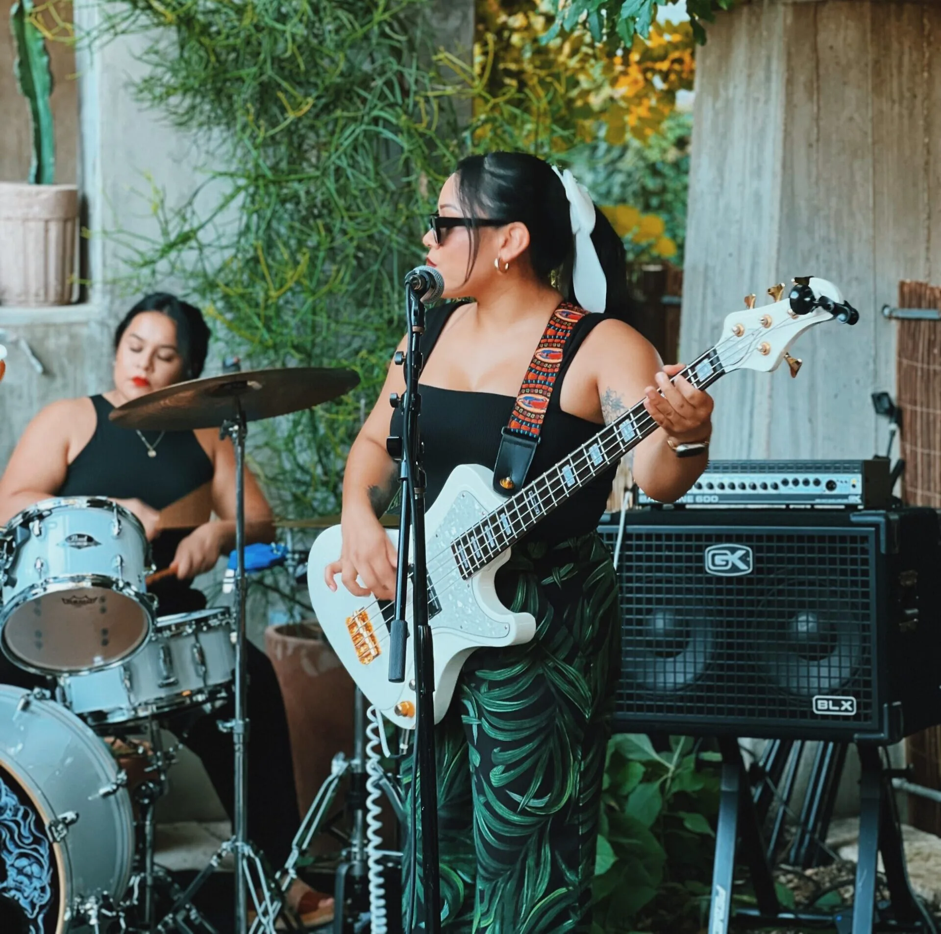 woman playing guitar and another woman playing the drums