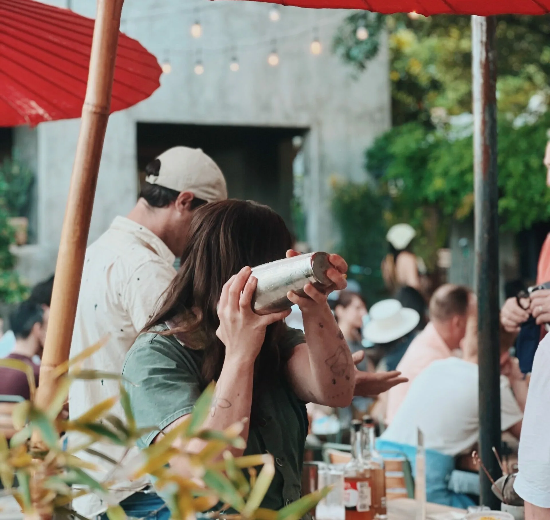 person shaking a drink in a metal canister at a bar