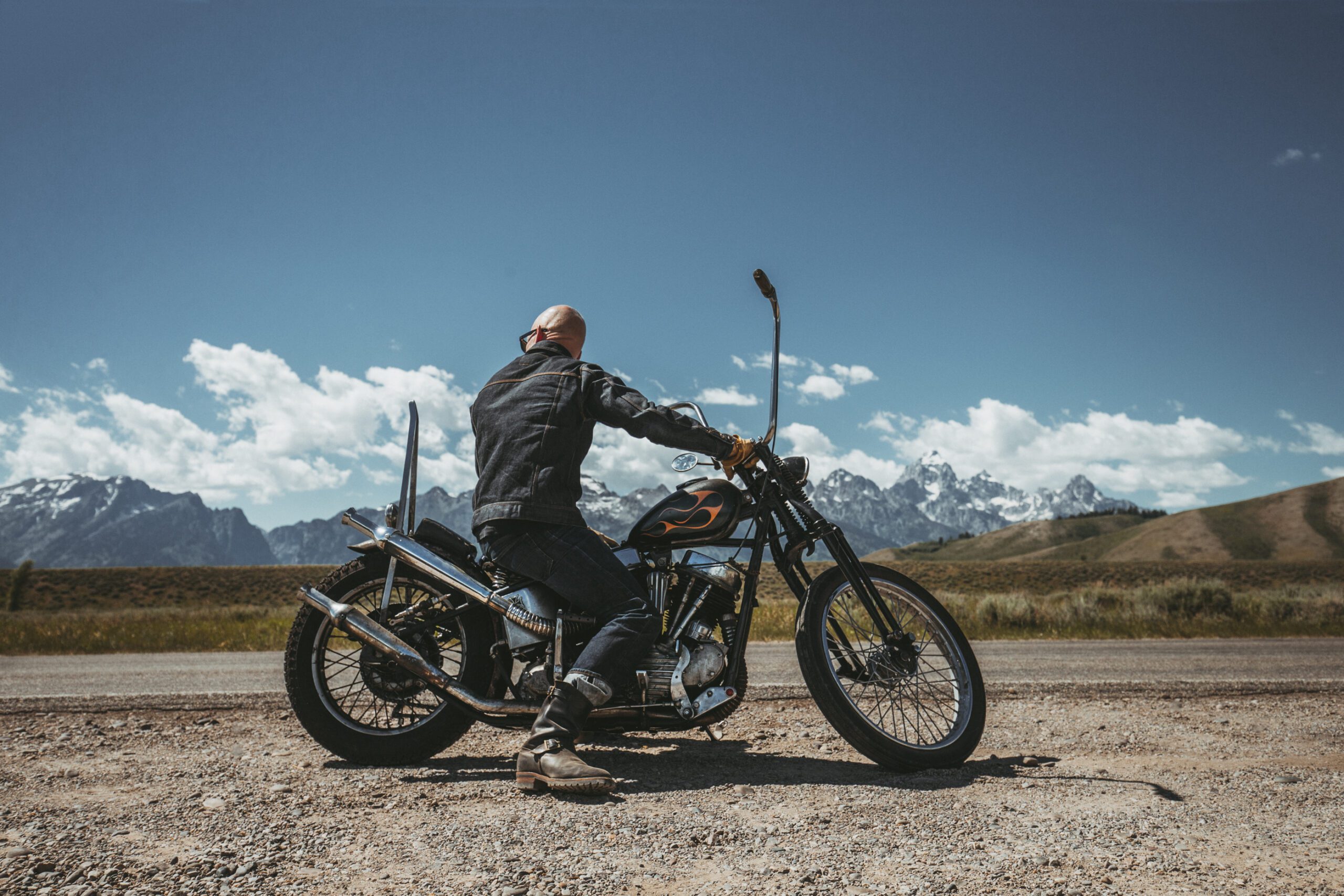 person sitting on a motorcycle with landscape background