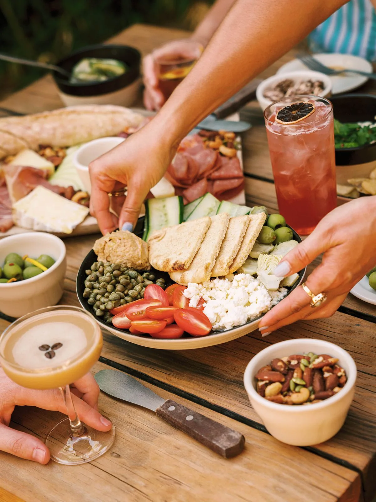 Hands placing hummus plate on table