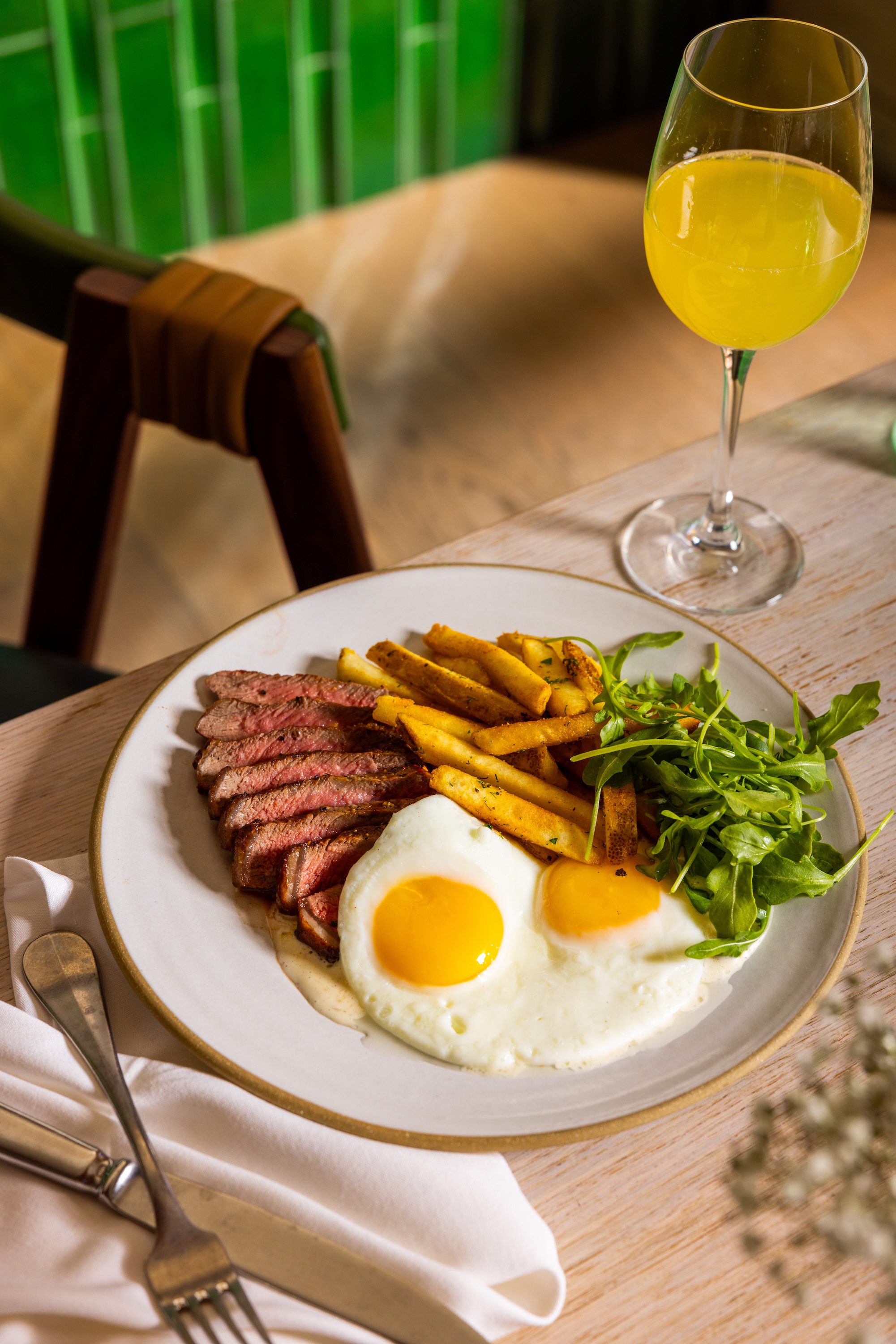 Steak and Eggs with a Mimosa on a table