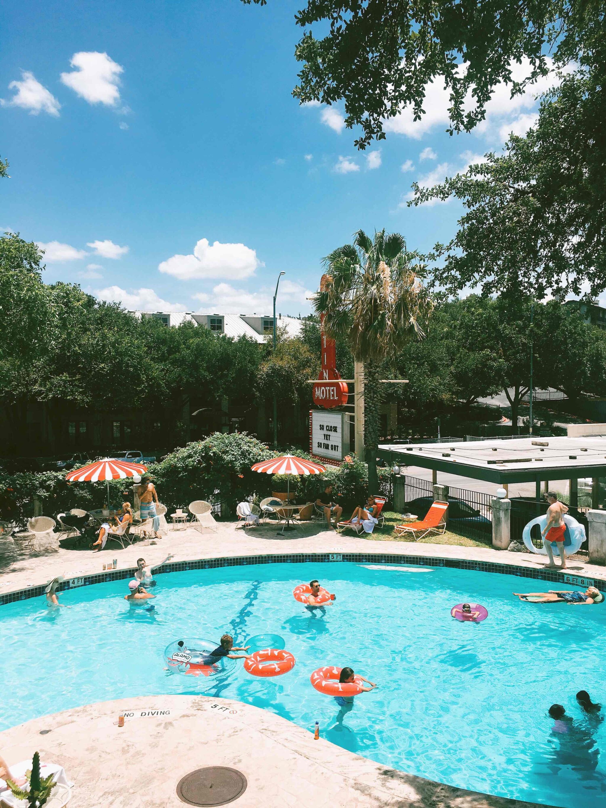 Austin Motel pool with various people floating in inner tubes