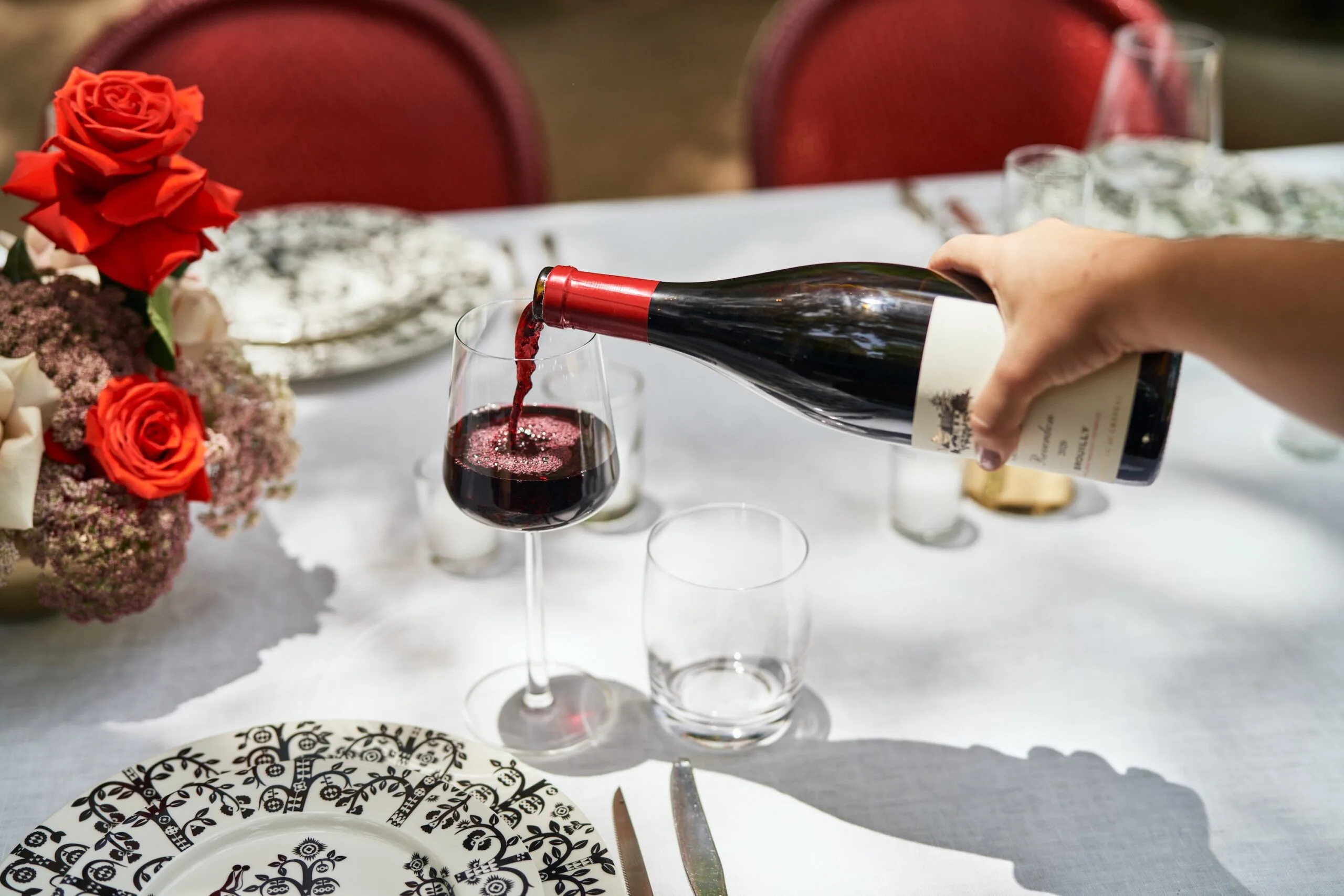 pouring wine into a glass on a fancy table