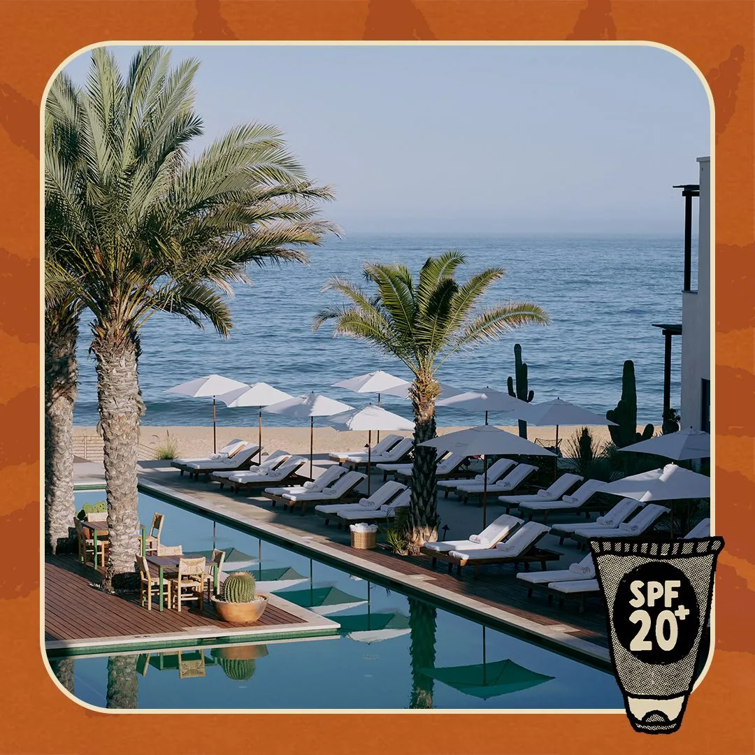 Lounge chairs around a pool with a border and a suntan lotion bottle with SPF 20+